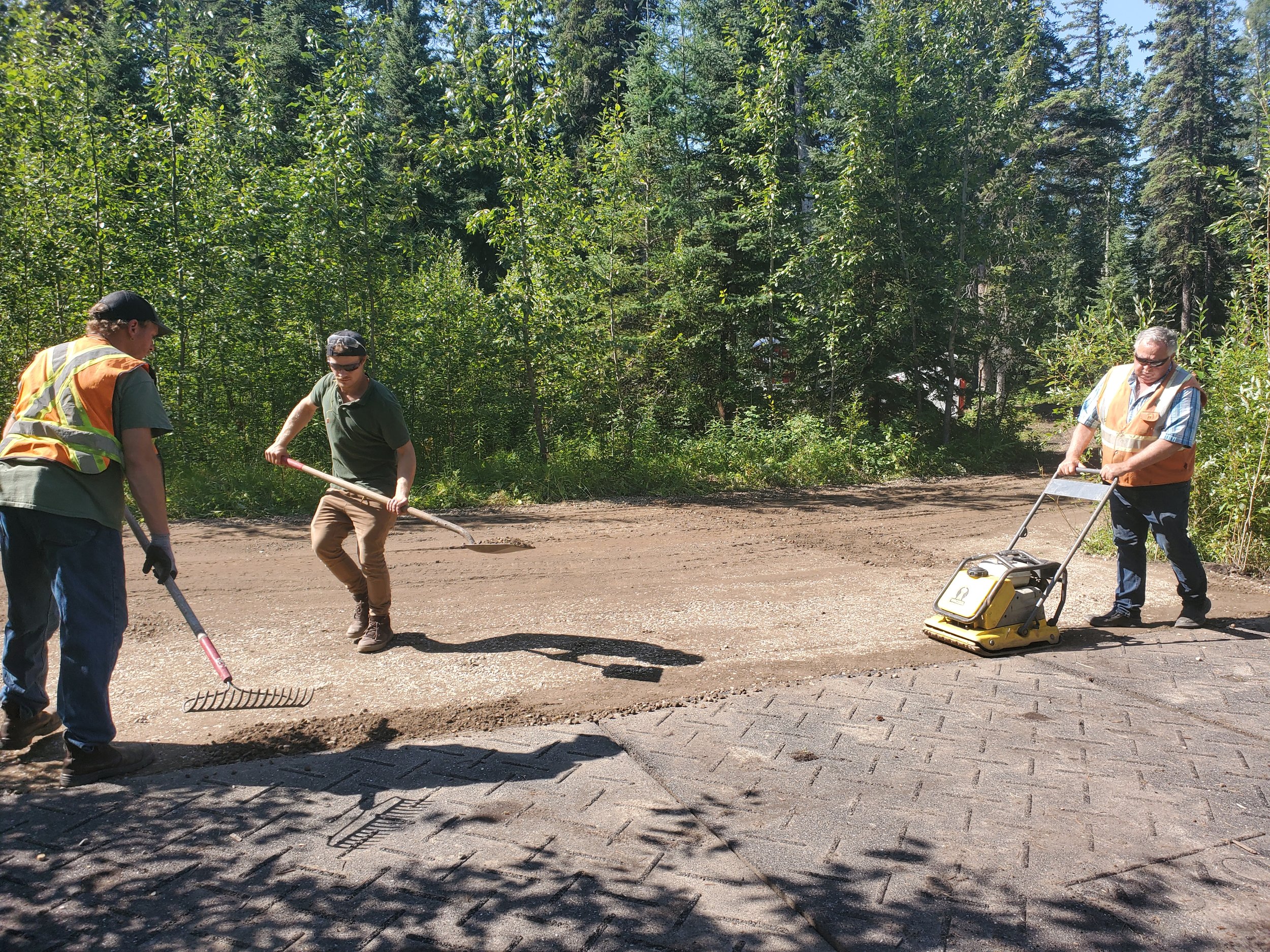 Packing and laying gravel in front of outdoor classroom pad