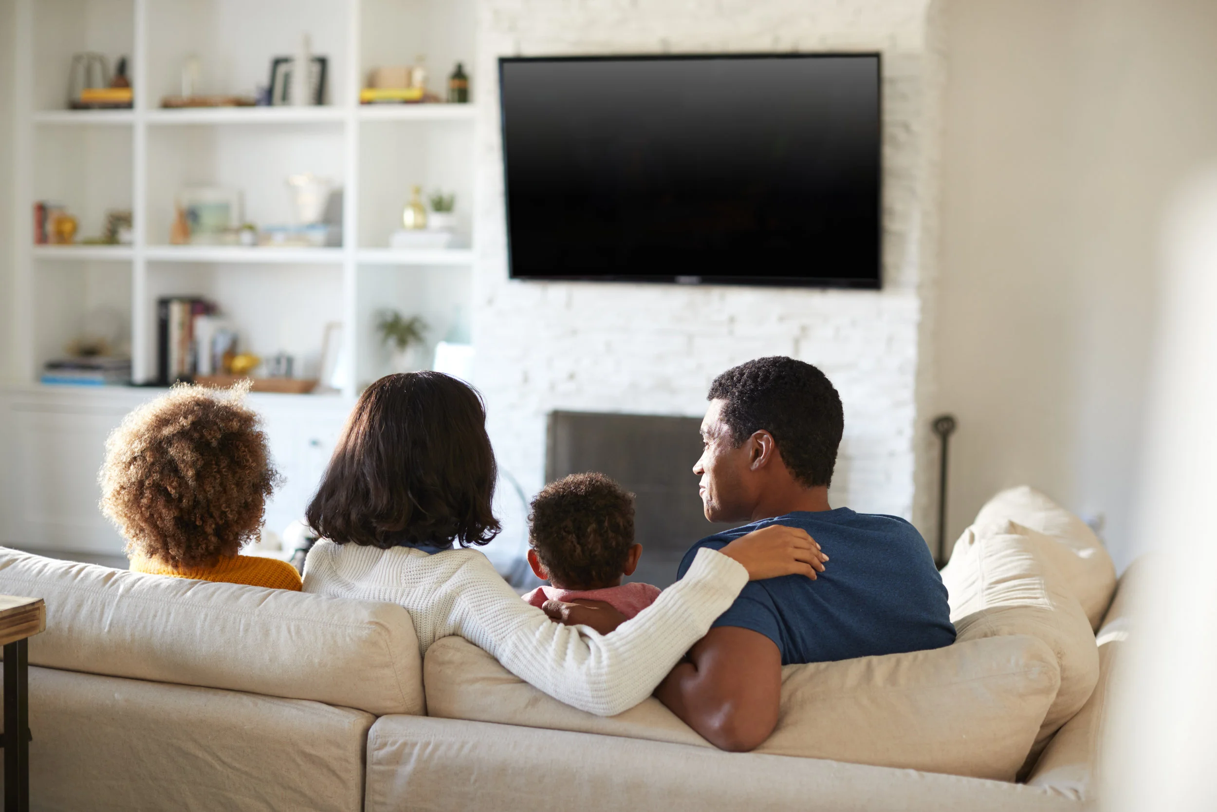 back-view-of-young-family-sitting-on-the-sofa-and-VC9D2YX.jpg