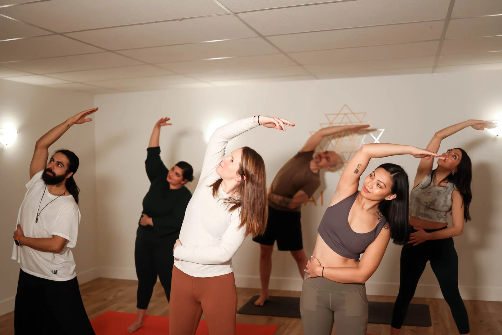 People practicing deep stretch yoga representing the 20-class pack savings