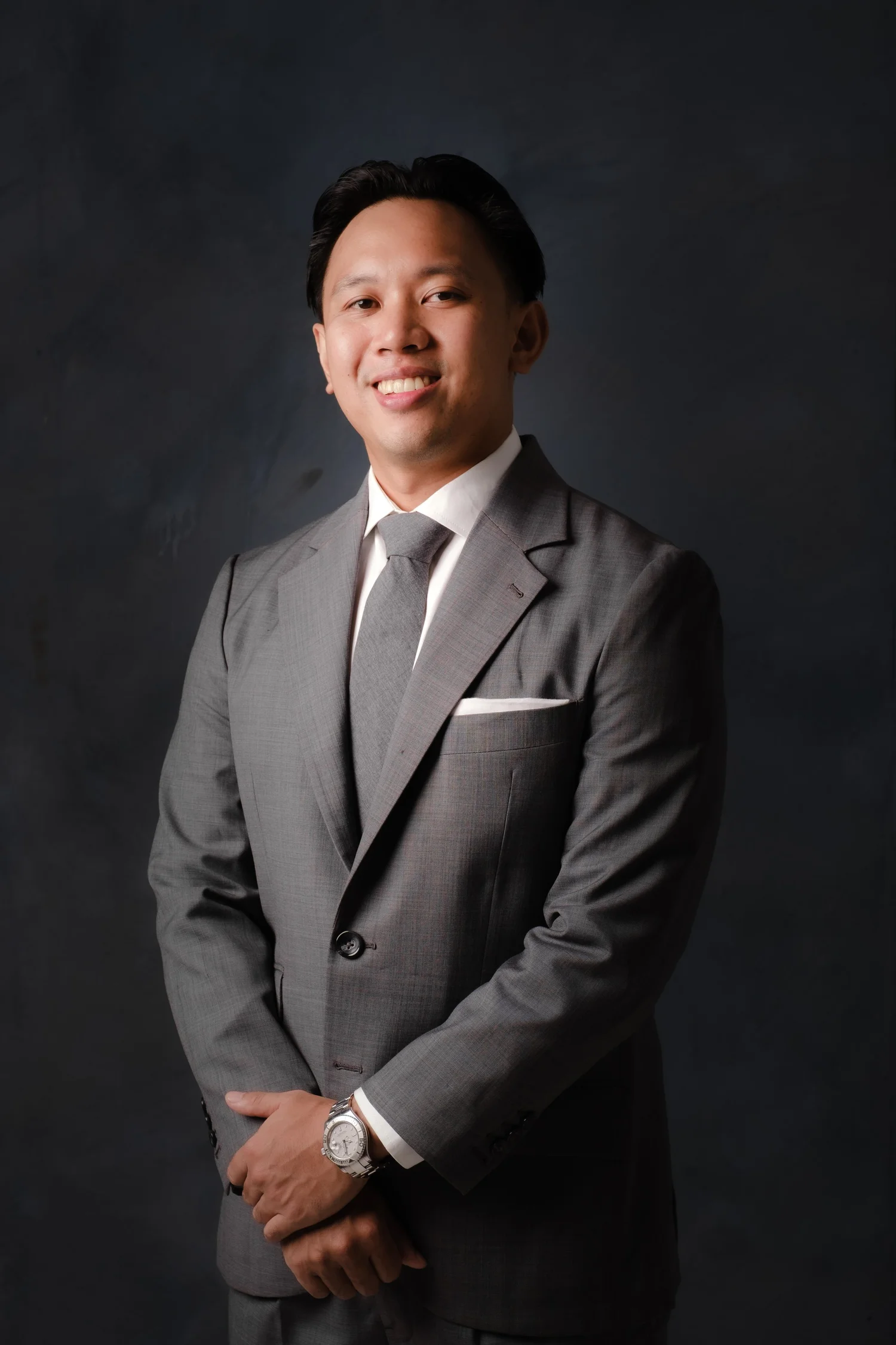 Studio headshot of a man in a charcoal suit.