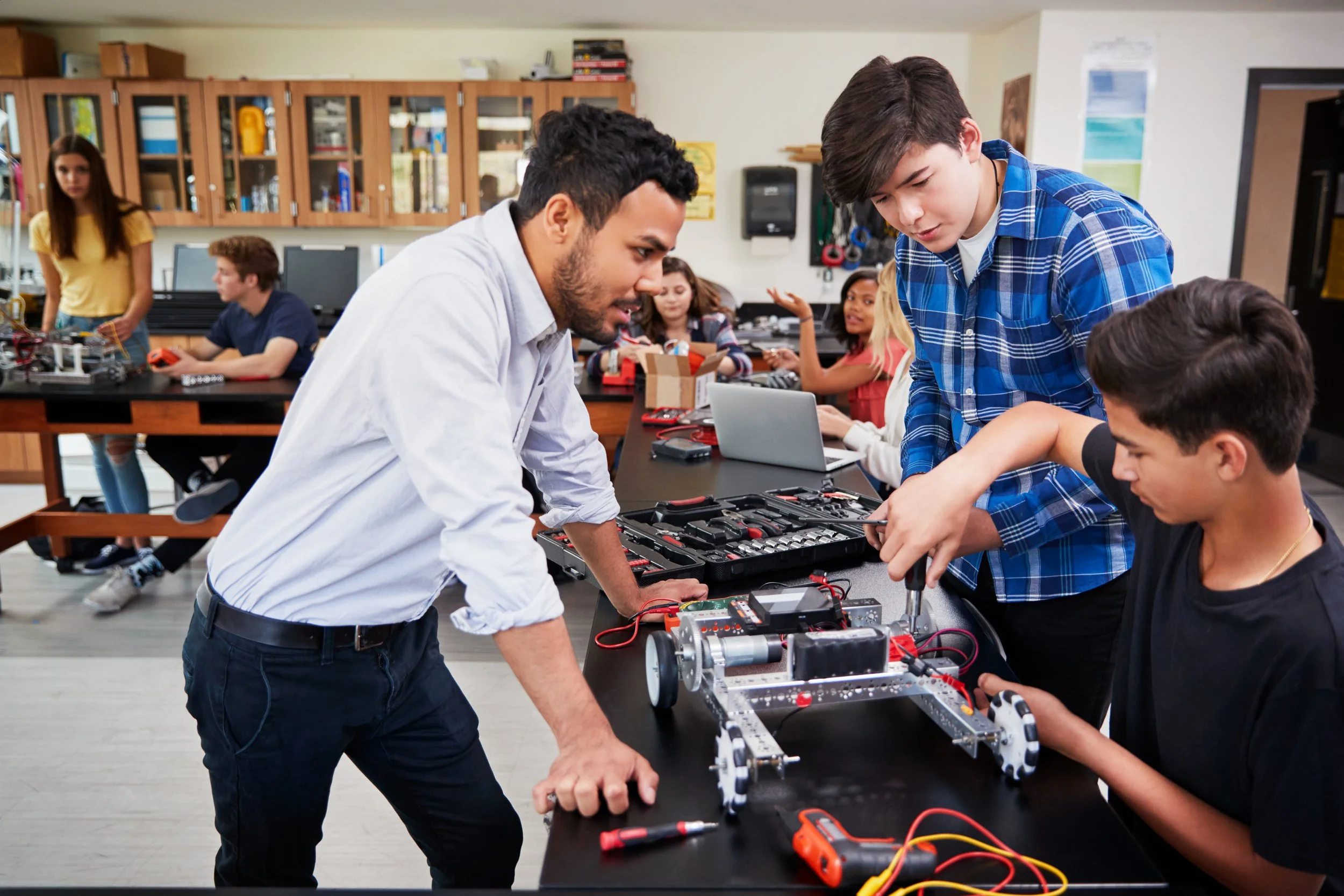 Students and teacher working on robotics project in classroom