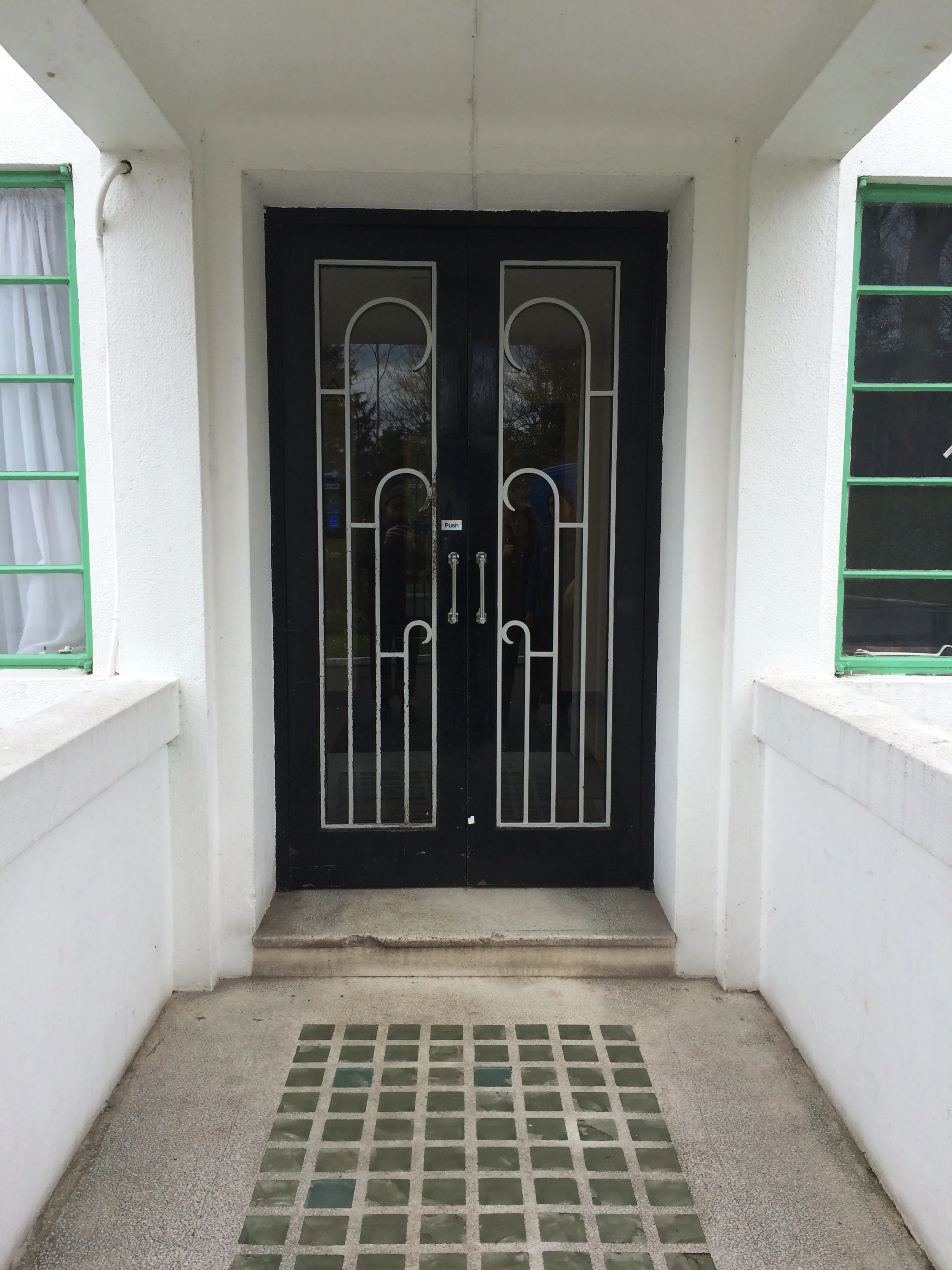  The covered building entrance with decorative 1930s doorframe 