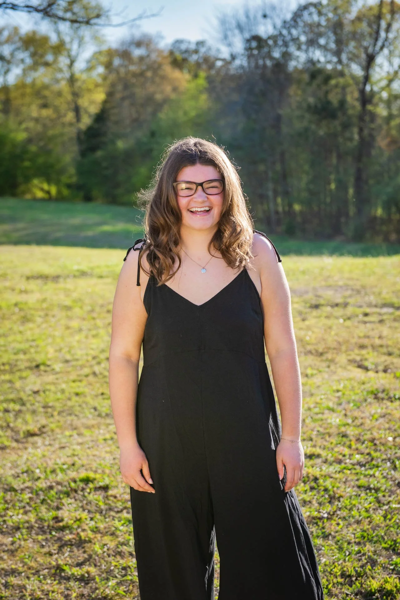 Senior girl in black jumpsuit laughing in open field Pell City Alabama, Darling Dear Photo