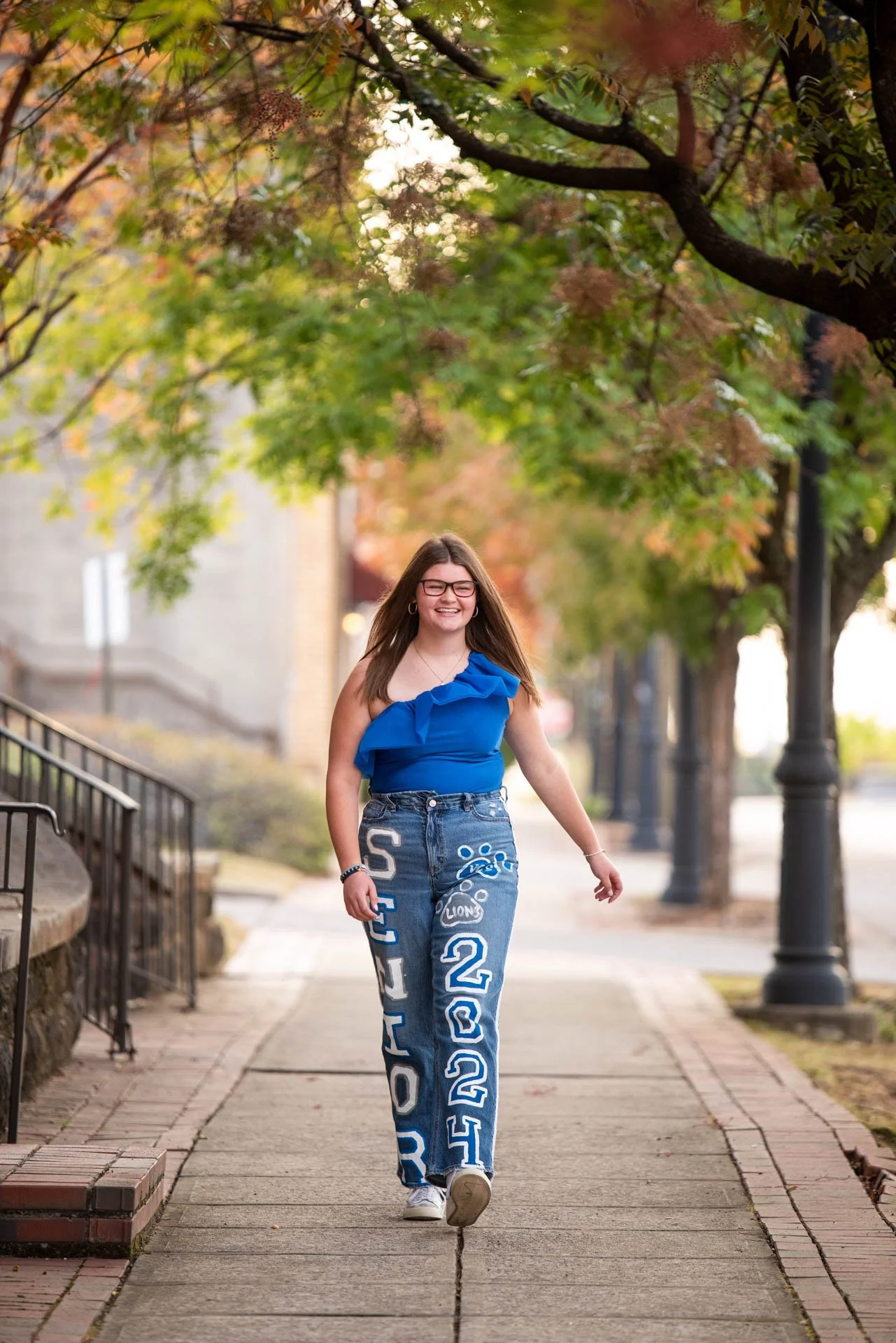 senior girl walking down street in custom made senior jeans in Birmingham Alabama
