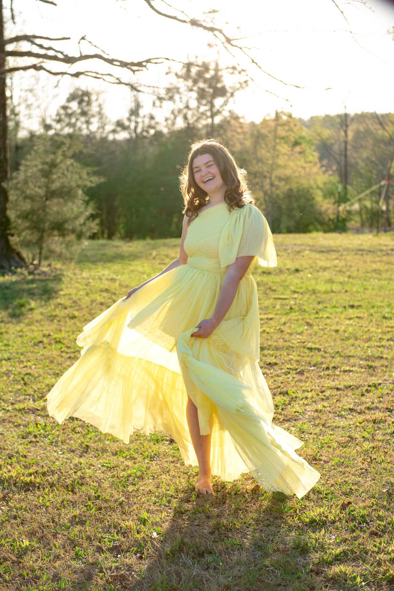 Senior girl twirling barefoot in yellow dress in Alabama field at golden hour, Darling Dear Photo