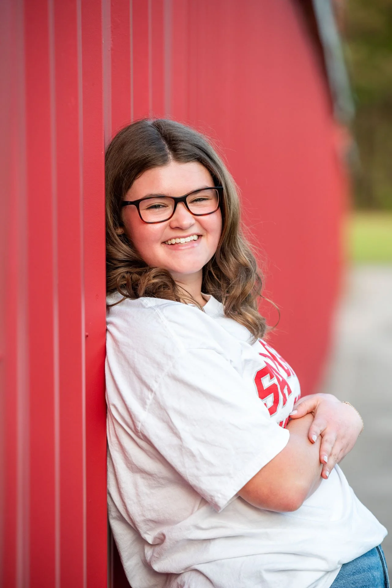 Senior girl in Samford University shirt leaning on red barn wall Pell City Alabama, Darling Dear Photo