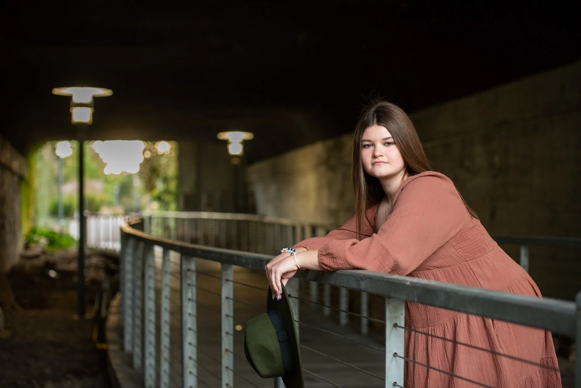 Senior girl in rust dress leaning on railing in Birmingham Alabama, Darling Dear Photo