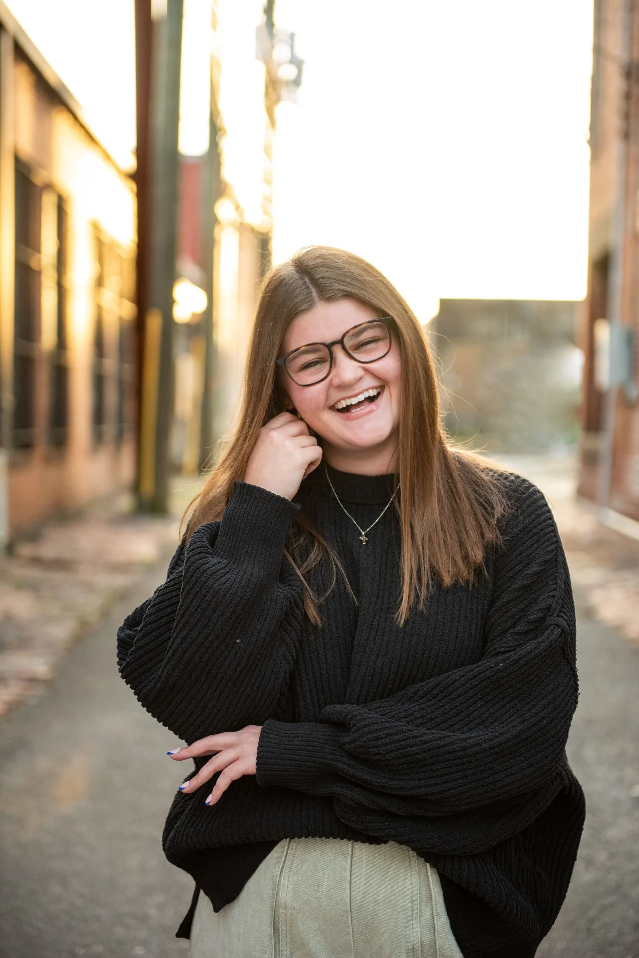 High school senior laughing in golden hour alley in Birmingham Alabama, black sweater, Darling Dear Photo