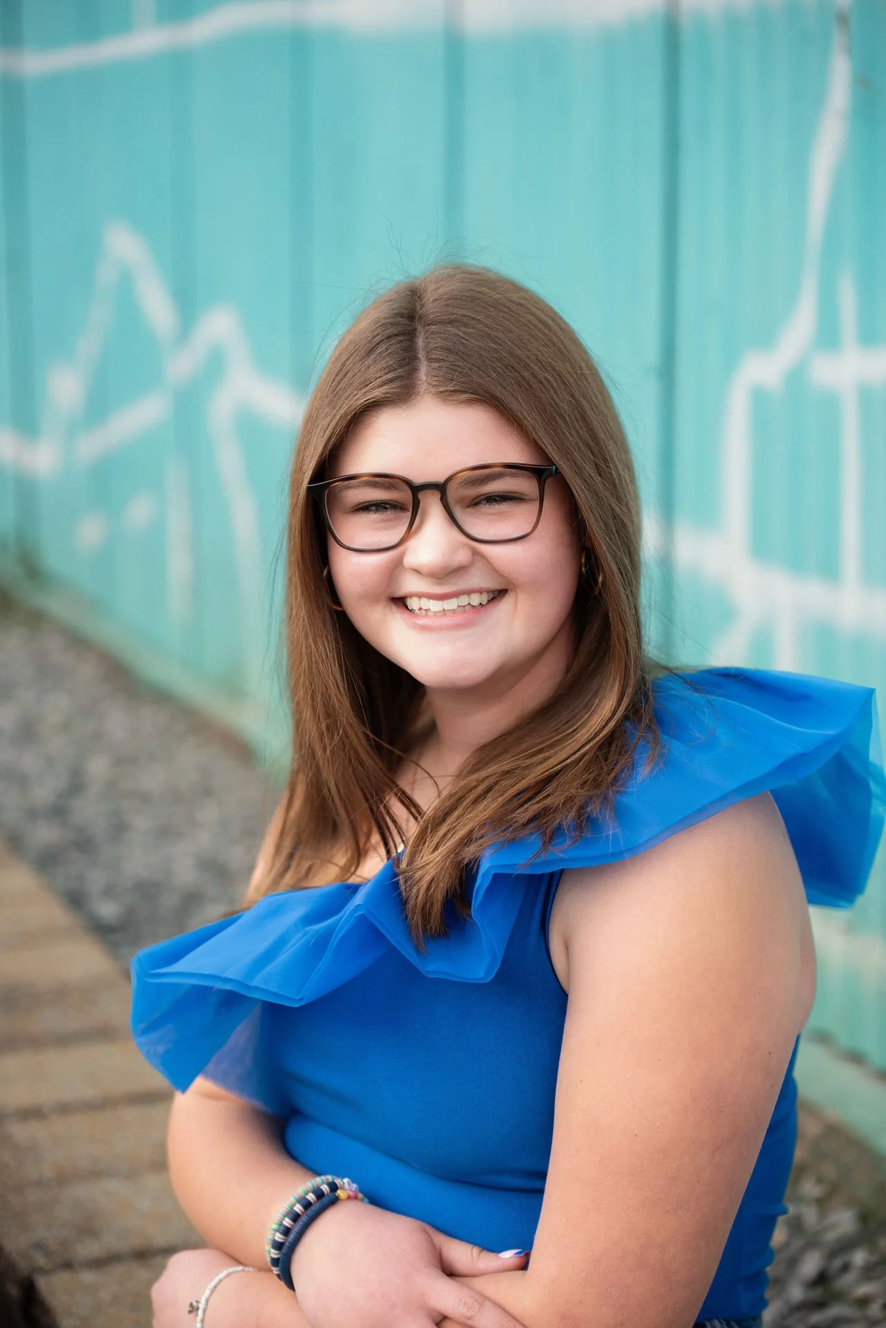 Senior girl in blue top laughing in front of Birmingham Alabama mural, Darling Dear Photo