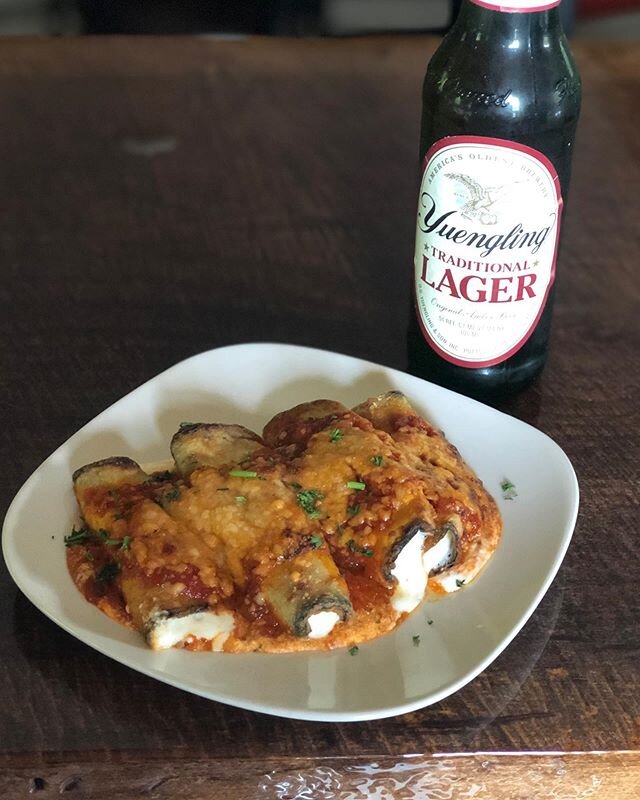 What better way to spend your Sunday than sitting outside having a few cocktails and some delicious homemade food?! Pictured here is an ice cold @yuenglingbeer with eggplant rollatini which equates to fresh eggplant rolls stuffed with ricotta, layere