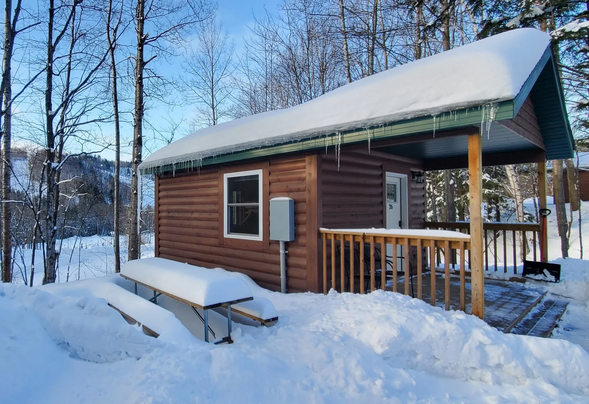 Snow-covered rustic cabin in the woods at Rippling River Resort in Marquette, Michigan
