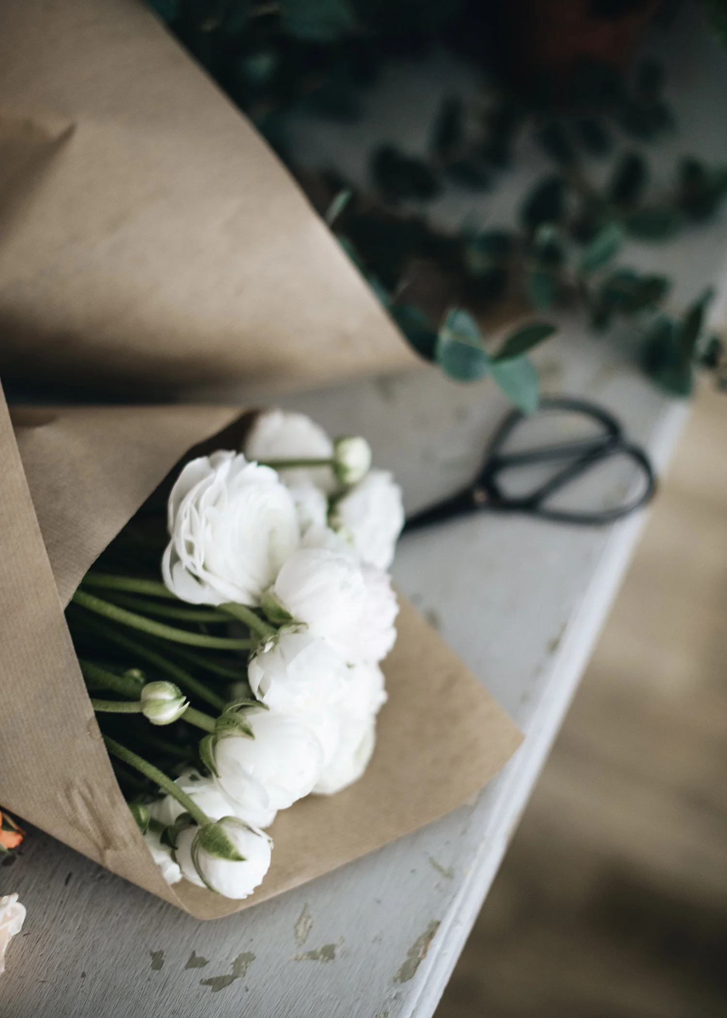 9-white-ranunculous-wrapped-in-brown-paper.jpg