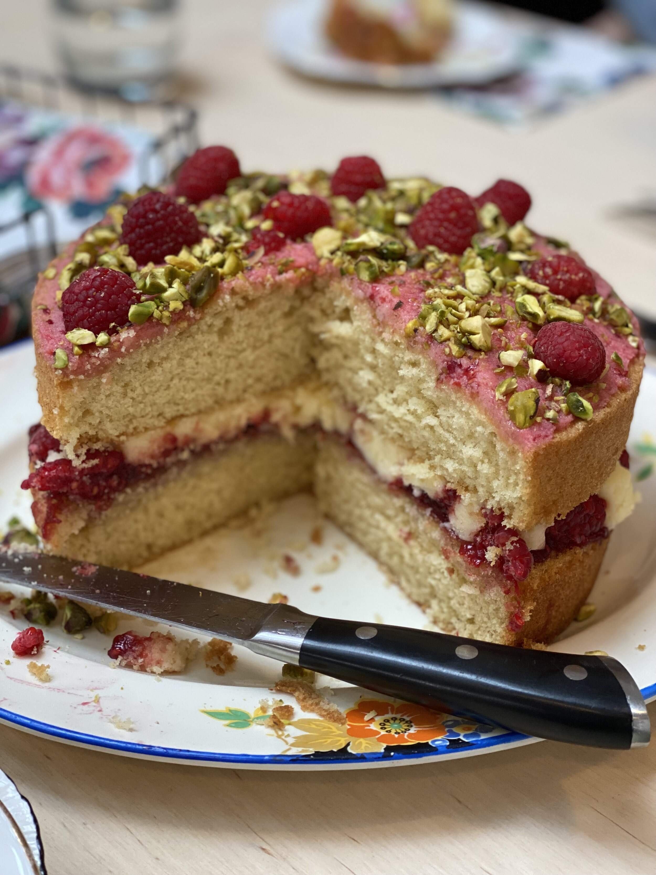 A delicious raspberry and pistachio cake on a vintage plate 