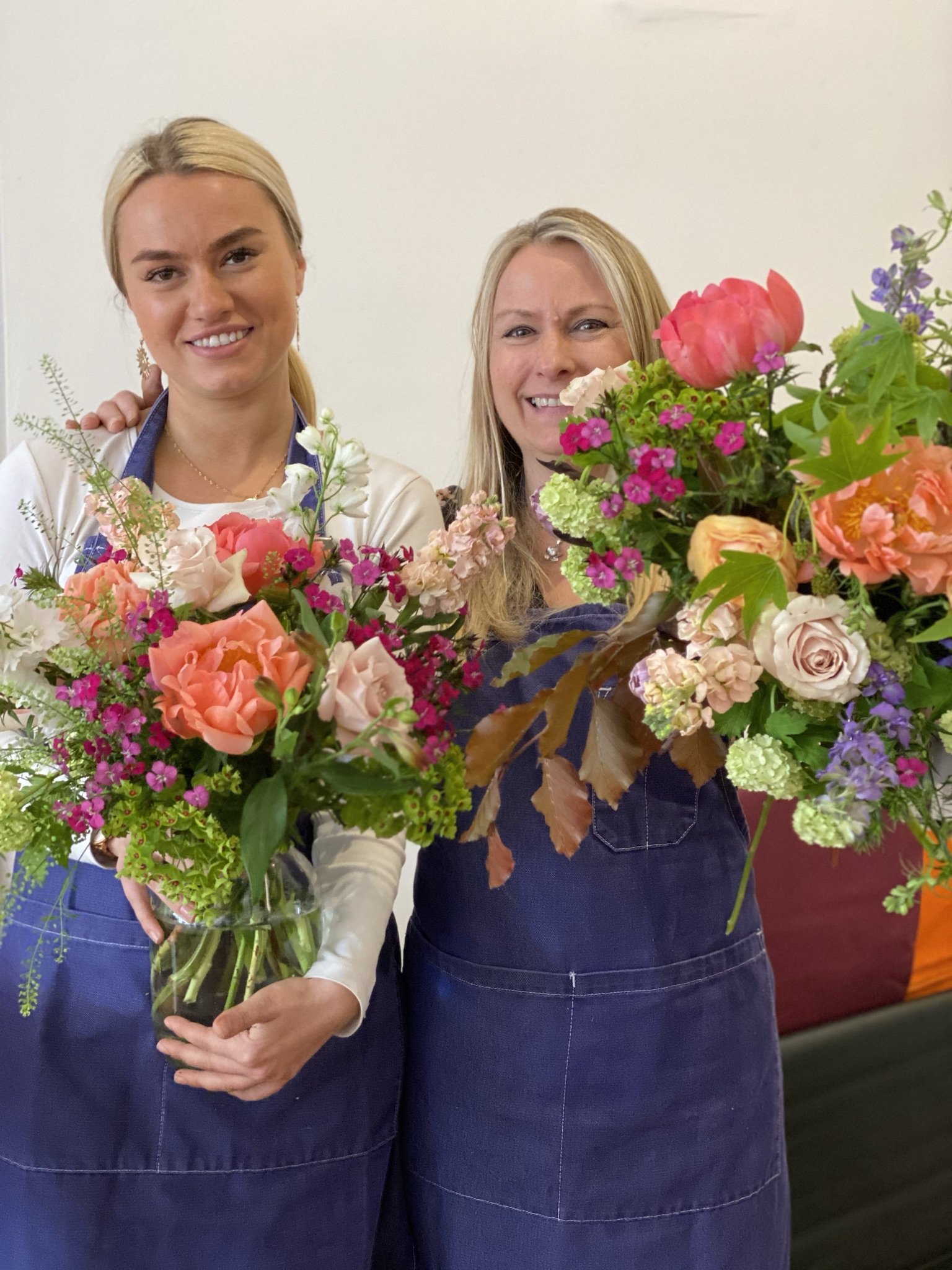 Mother and daughter holding their bunches of flowers created on the hand tied bouquet course