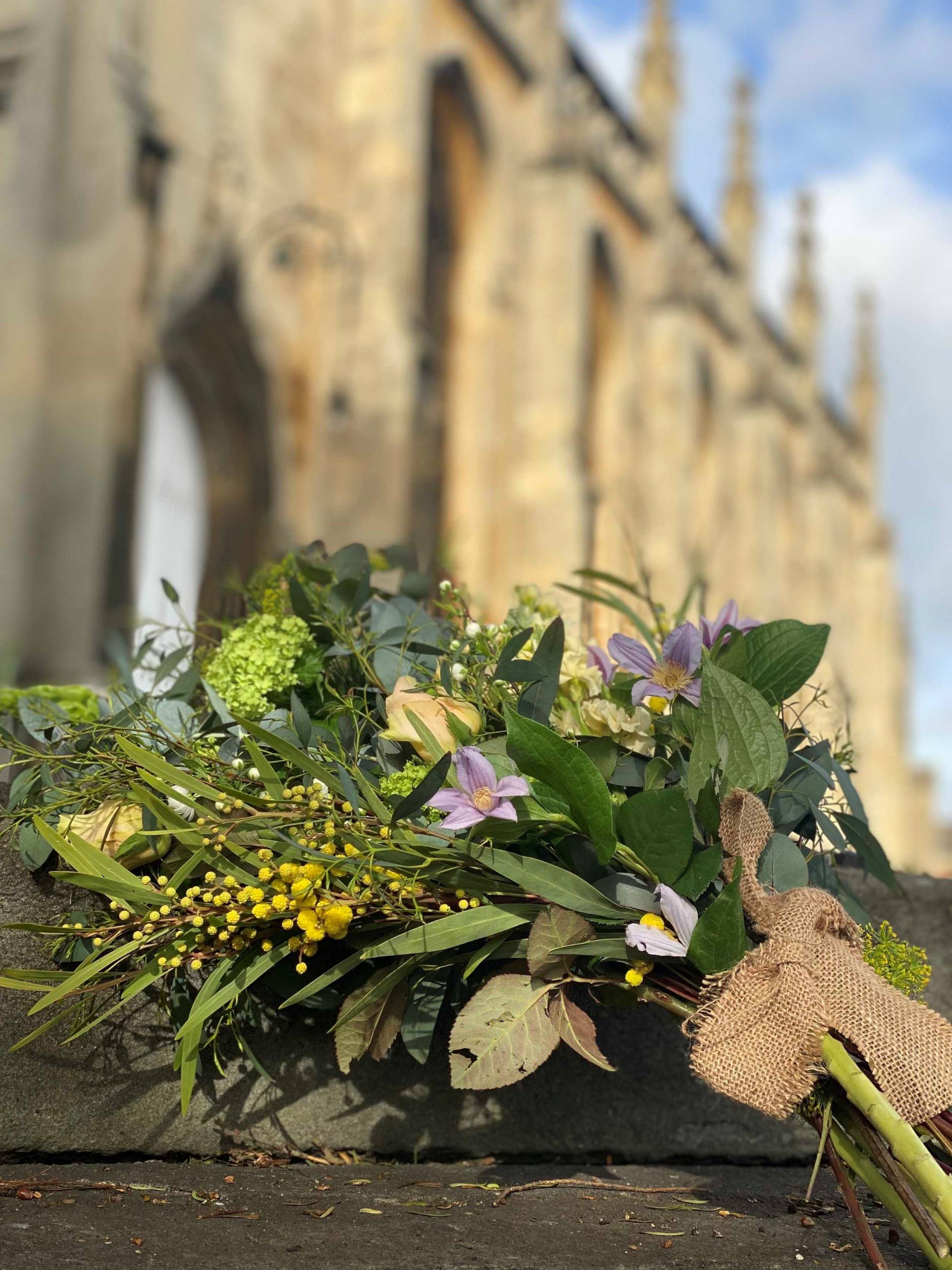 Naturally styled sympathy sheaf flowers place in front of a church