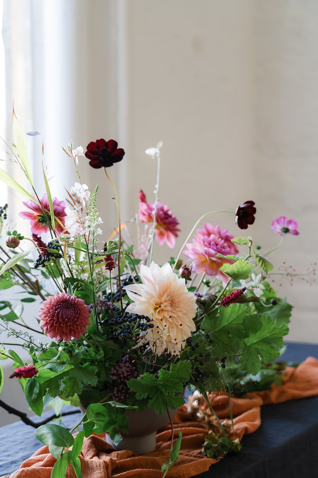 Garden inspired table centre with pink and deep burgundy flowers