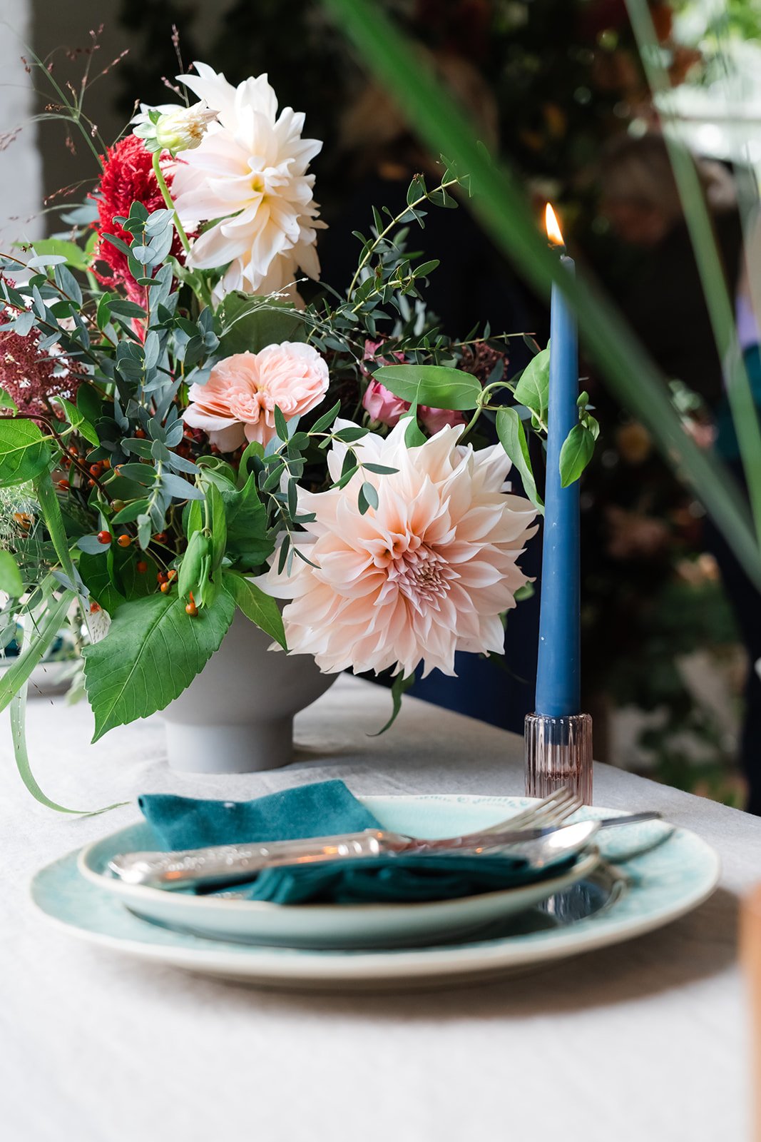 Stunning table setting with eco friendly floristry methods and bright blue candles
