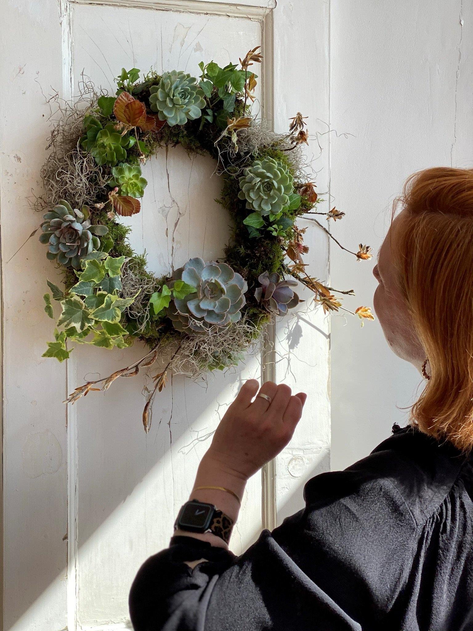Bath flower school teacher tending to a living wreath 