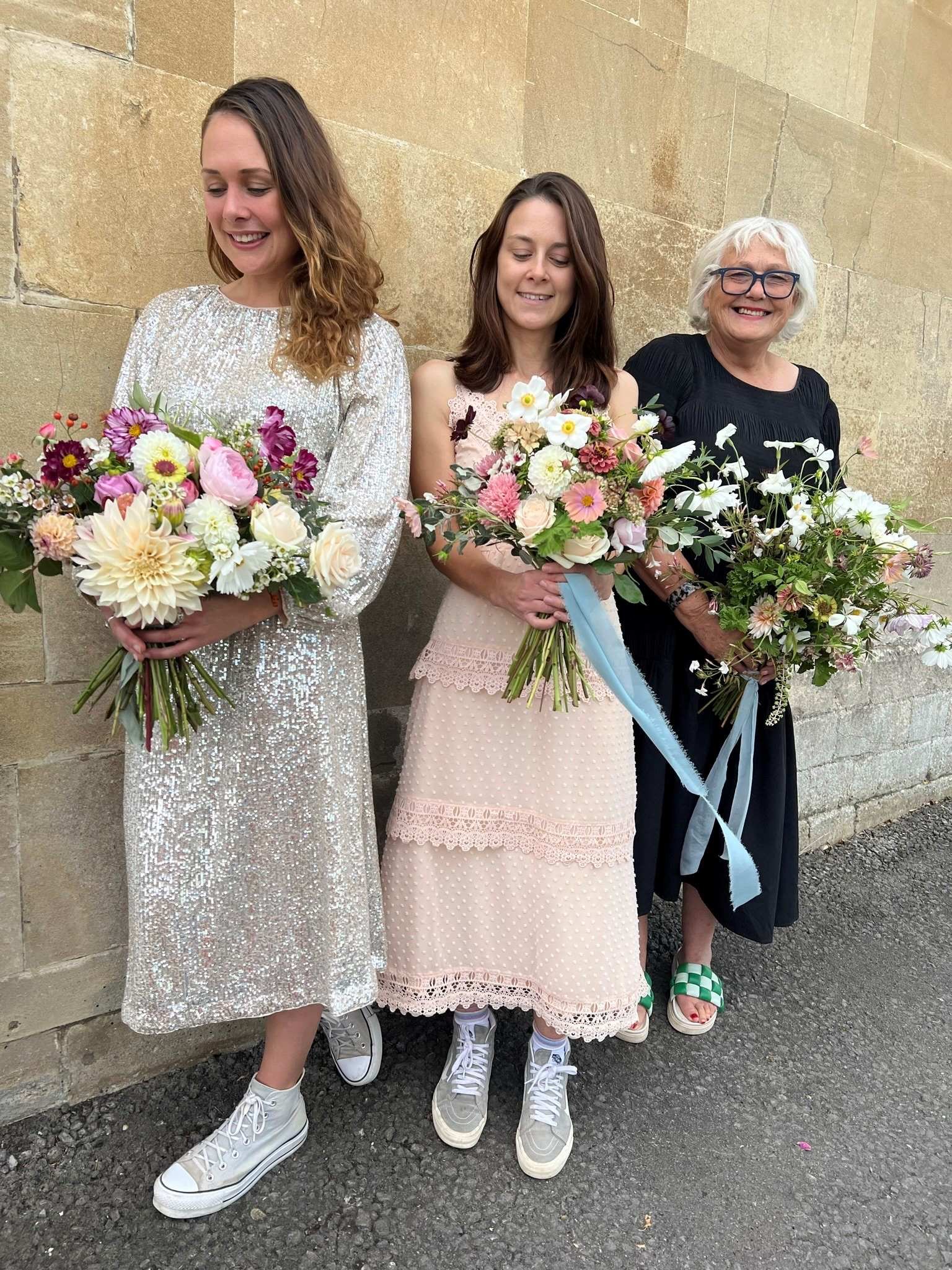 Students in wedding dresses holding their bridal bouquet creations