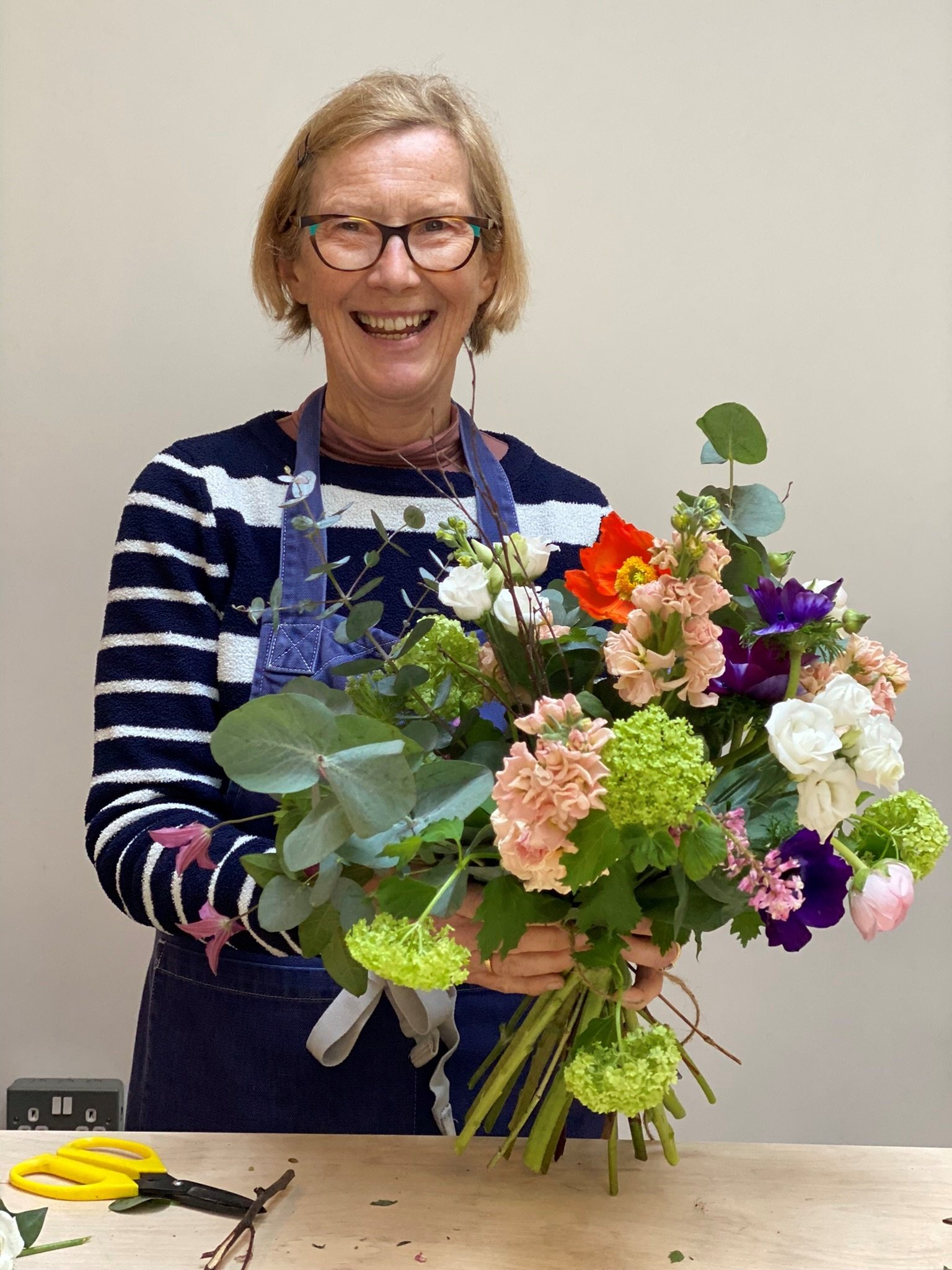 Bath's flower school student holding a vibrant spring hand tied bouquet