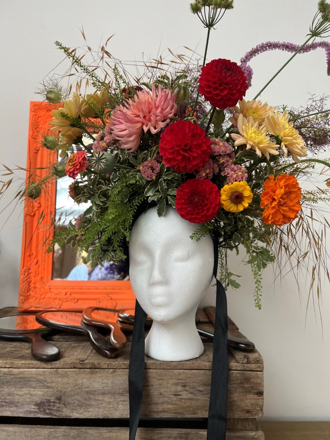 Brightly coloured British flower crown against fluro orange mirror