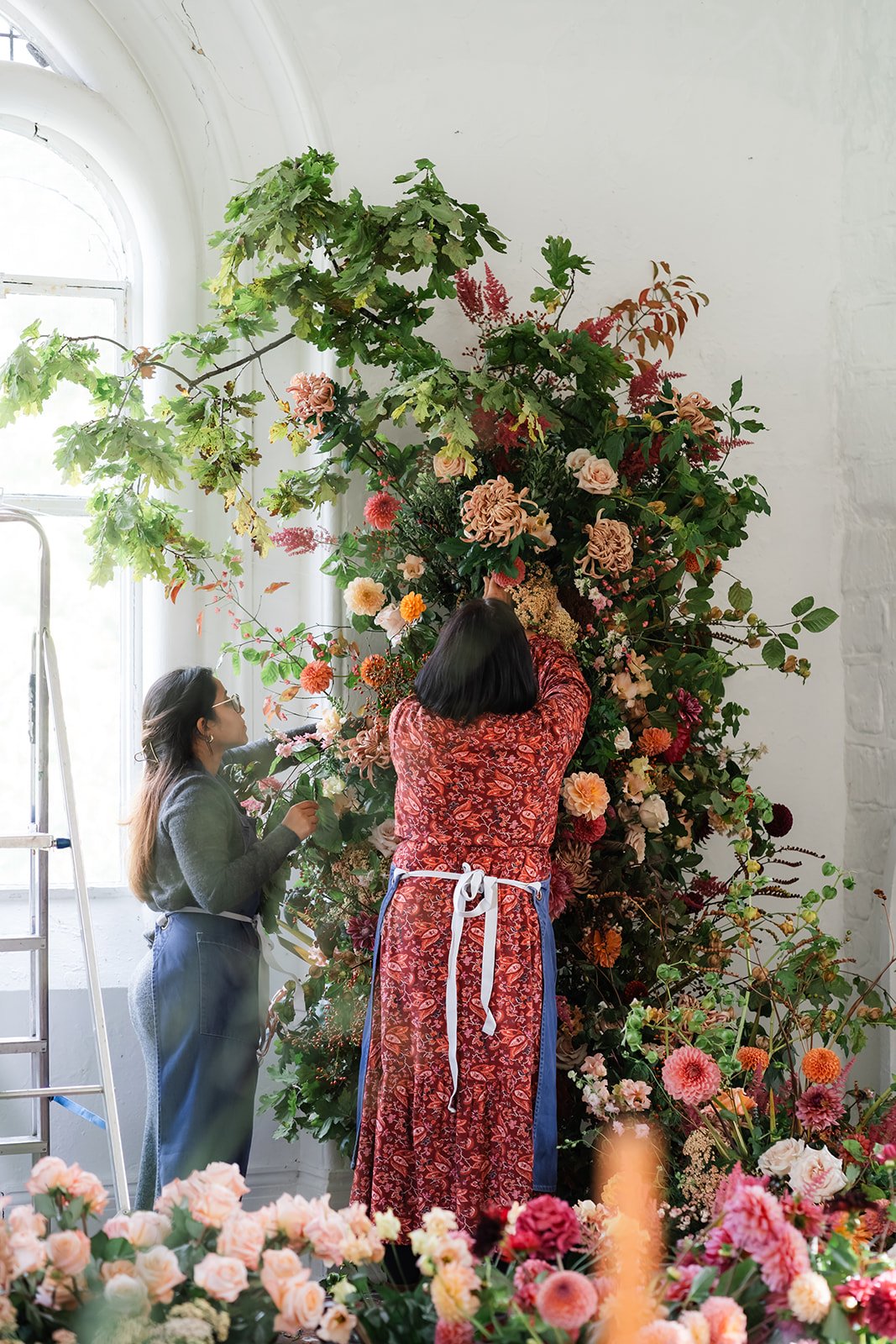 Wedding flowers course students working on large floral autumnal installation