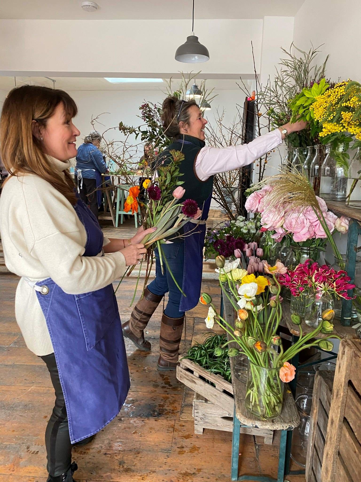 Two floristry basics students selecting seasonal flowers from the flower stand at The Bath Flower School