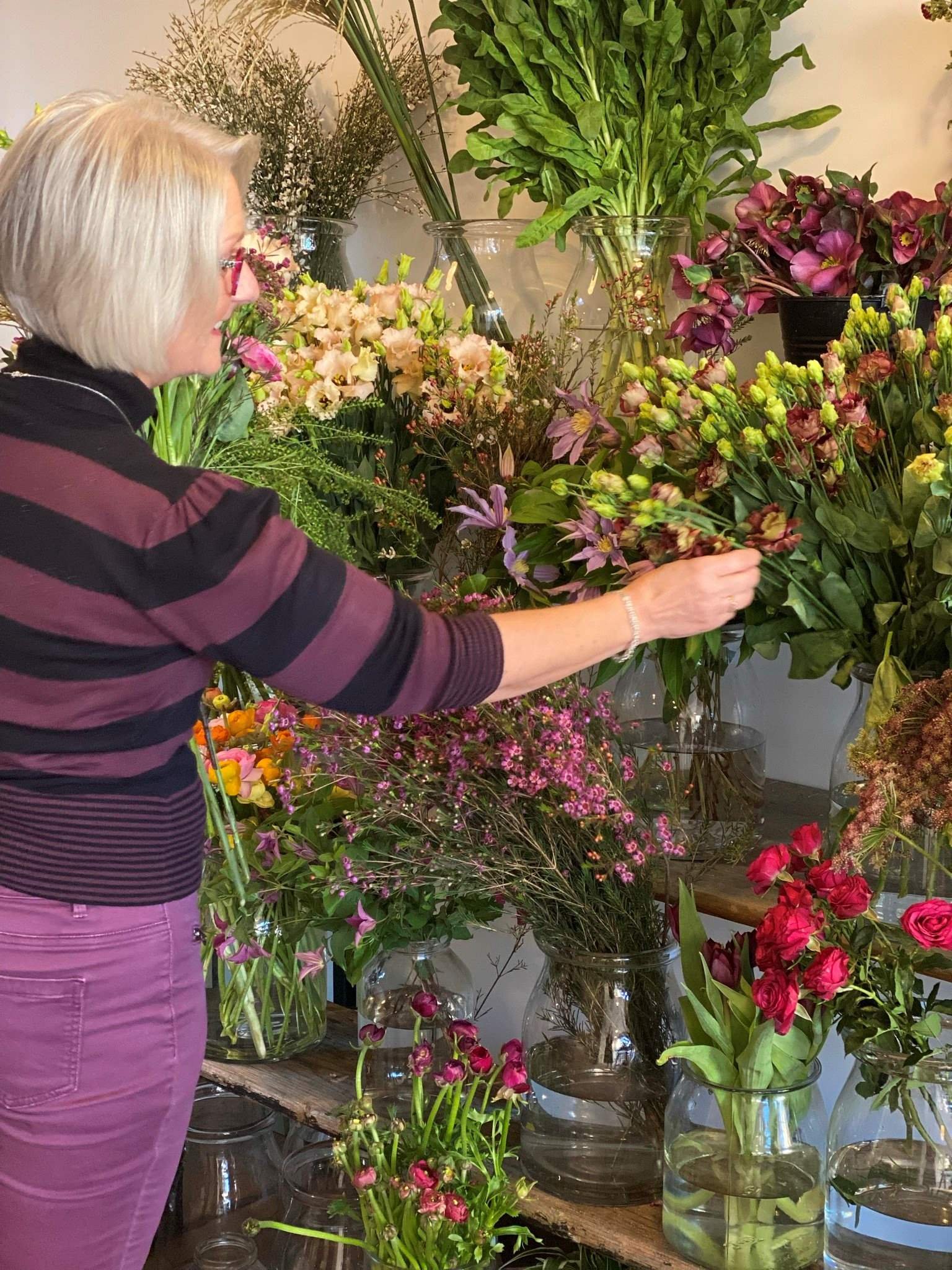 A floristry student selecting flowers from the floristry basics flower stand