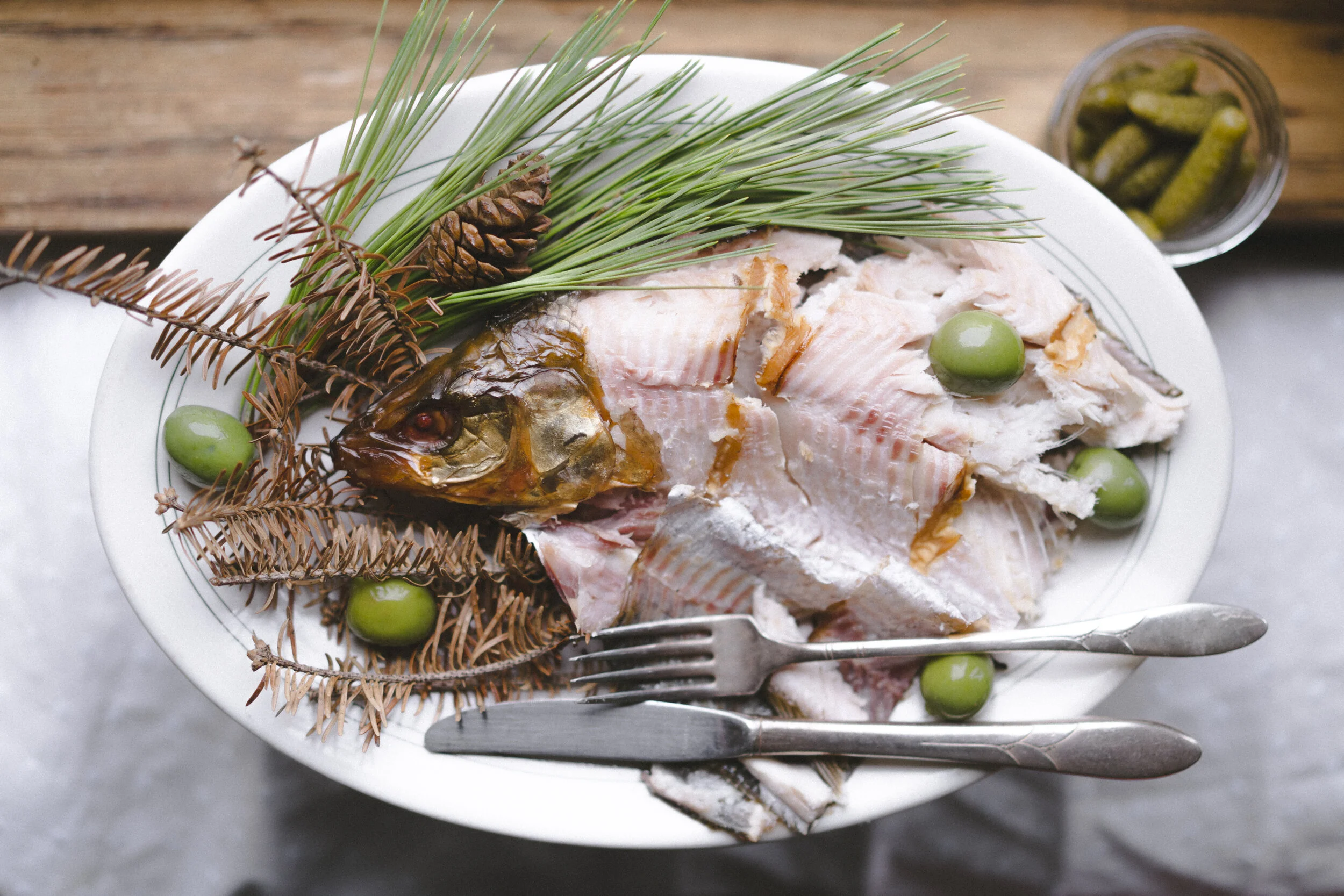 A Platter of Smoked Whitefish Garnished with Olives and Conifer Needles and Cones