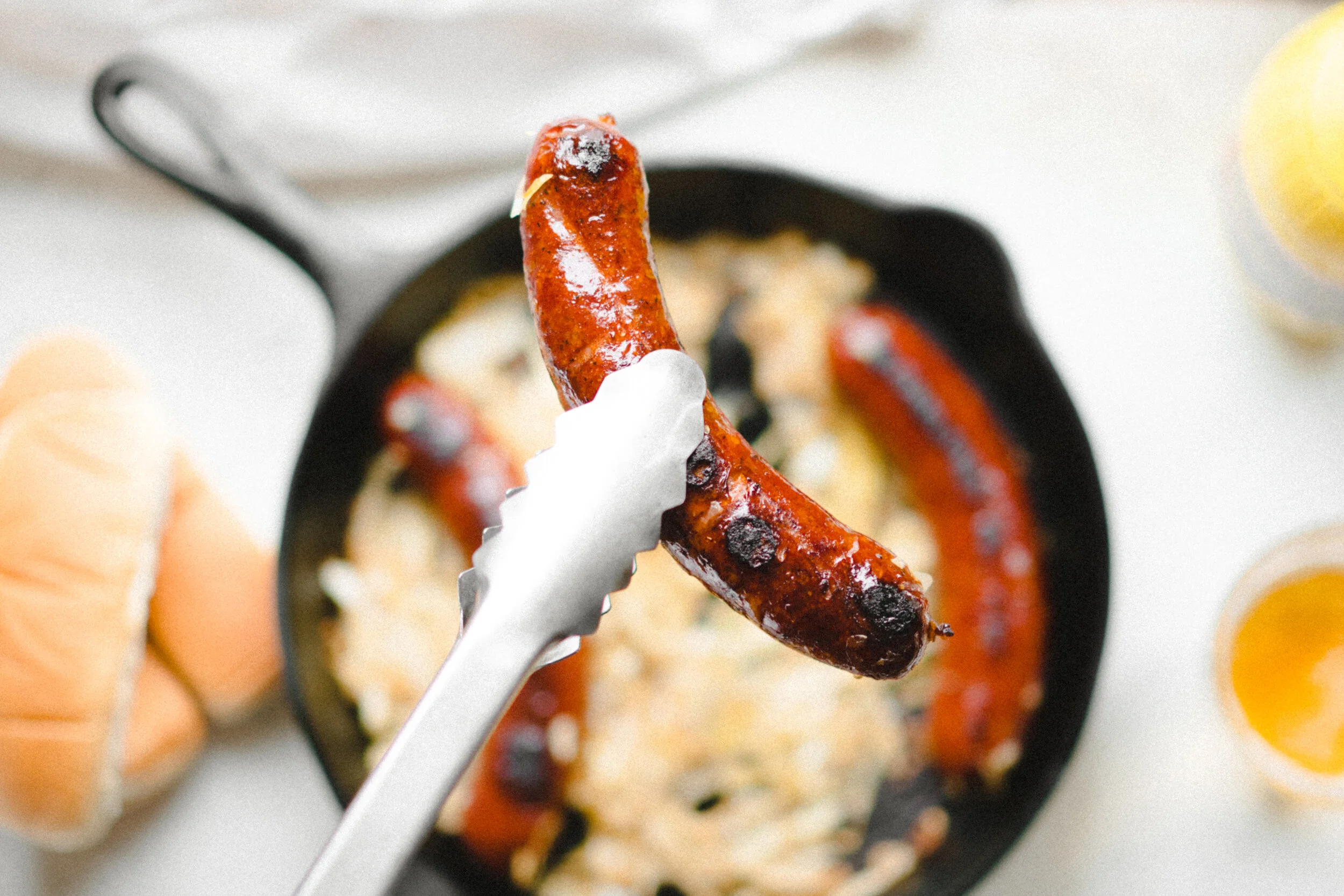 Artistic Shot of Smoked Polish Being Held Up By Tongs