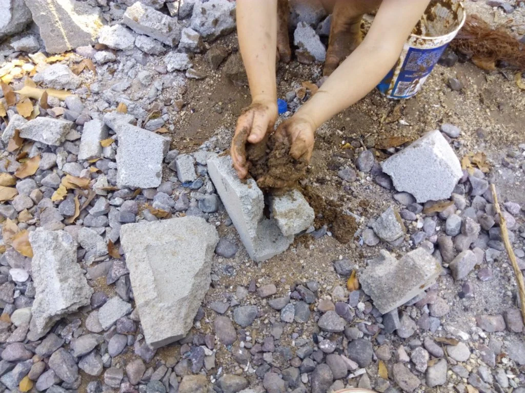 child playing with block and making pretend cement
