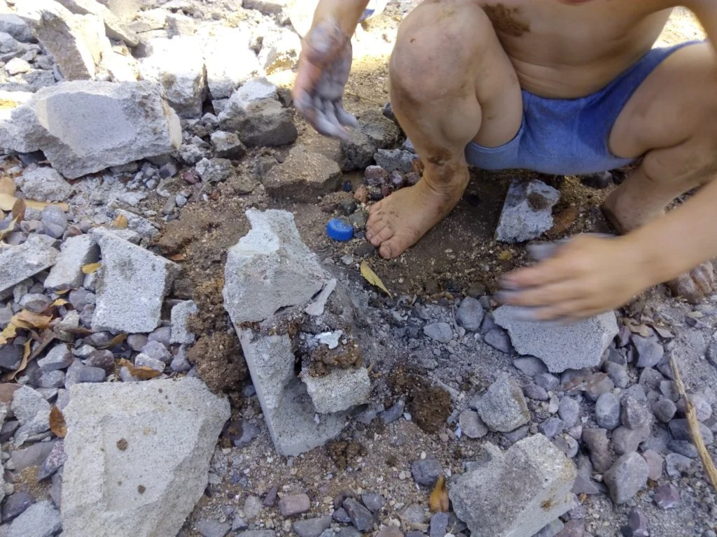 child playing with block and making pretend cement