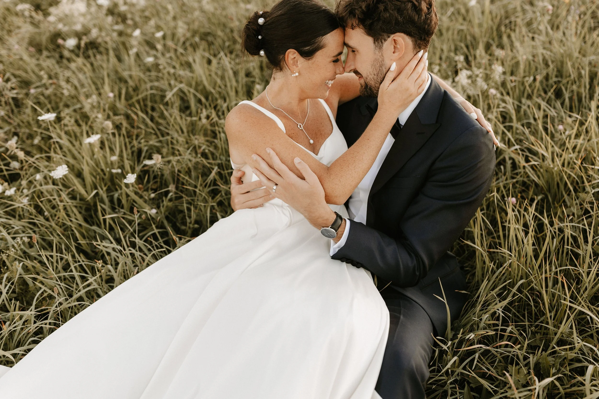 Beautiful bride and groom laying in quaint meadow at Notting Hill Farm barn wedding farm estate near Buffalo, NY