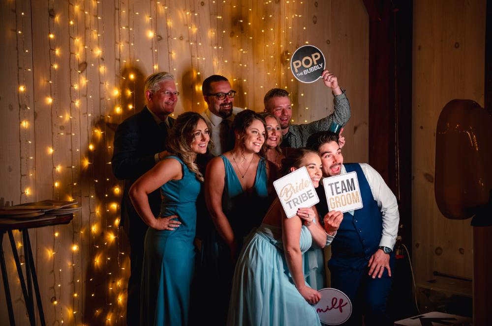 Wedding party photo booth fun at Notting Hill Farm, a premier barn wedding venue in Western New York with string lights