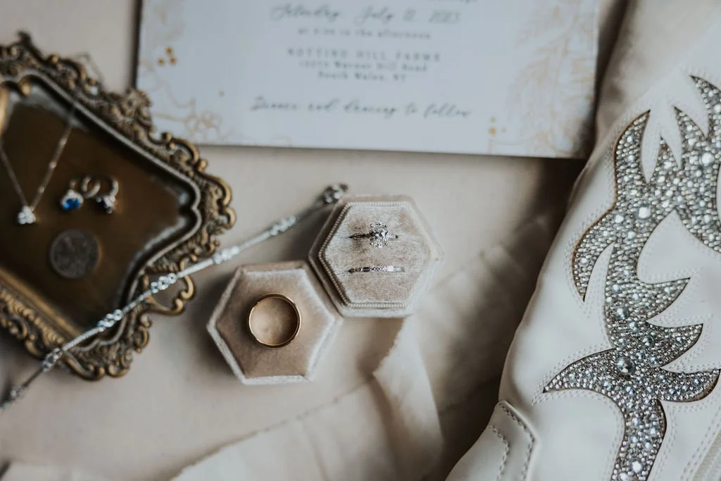 Wedding Band Set in ivory ring box on ivory background with white studded cowboy boots Buffalo NY