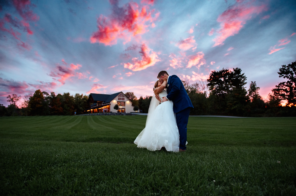 romantic sunset kiss on the lawn at Notting Hill Farm, a scenic wedding venue in Western New York