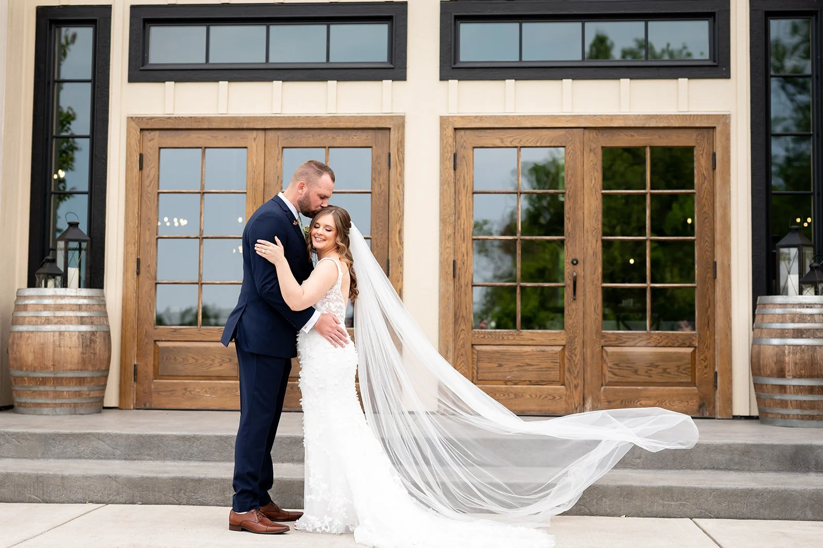 Wedding couple embracing in front of barn wedding venue reception hall in Buffalo, NY