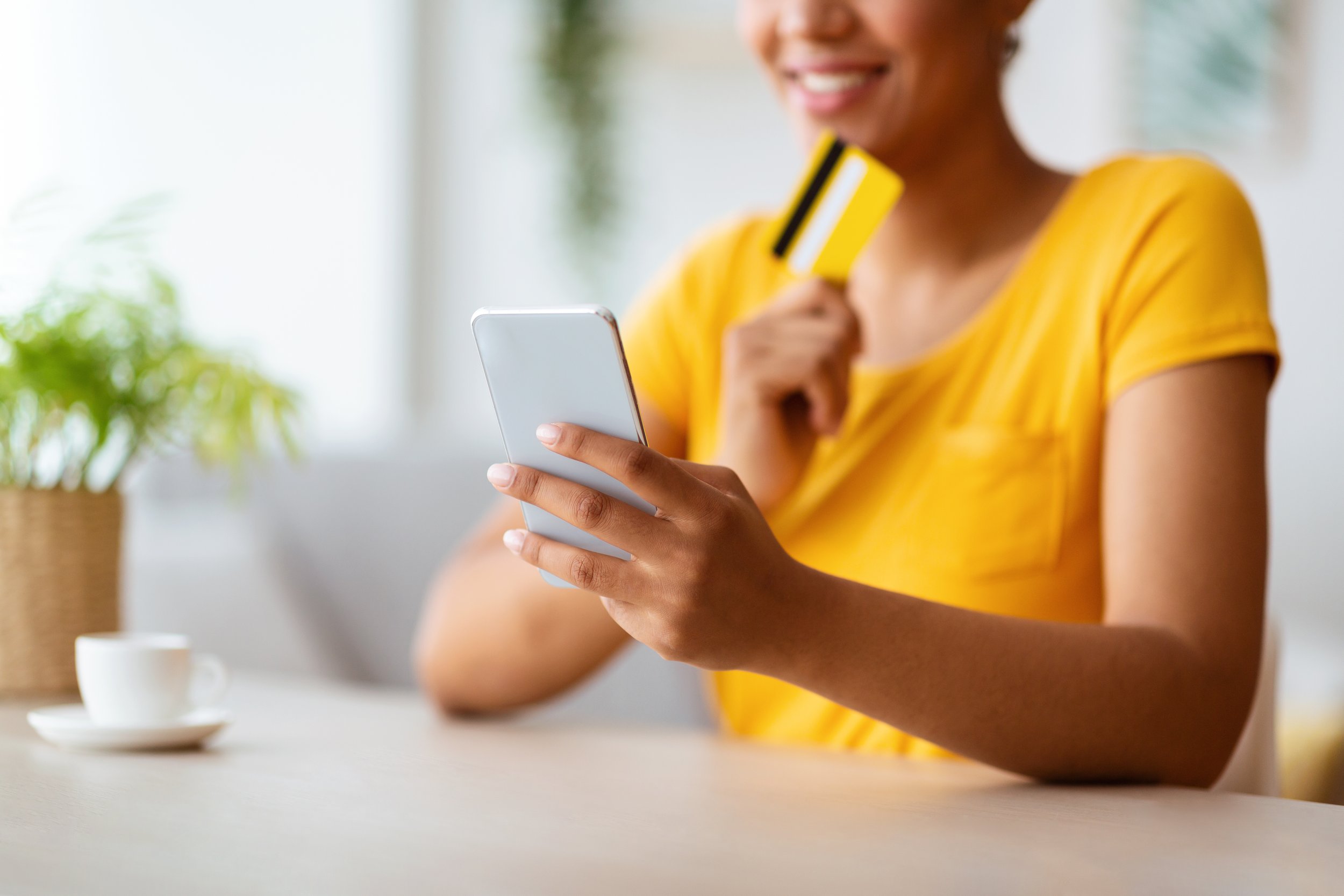 black-lady-using-phone-and-credit-card-at-home-2023-11-27-05-34-41-utc.jpg