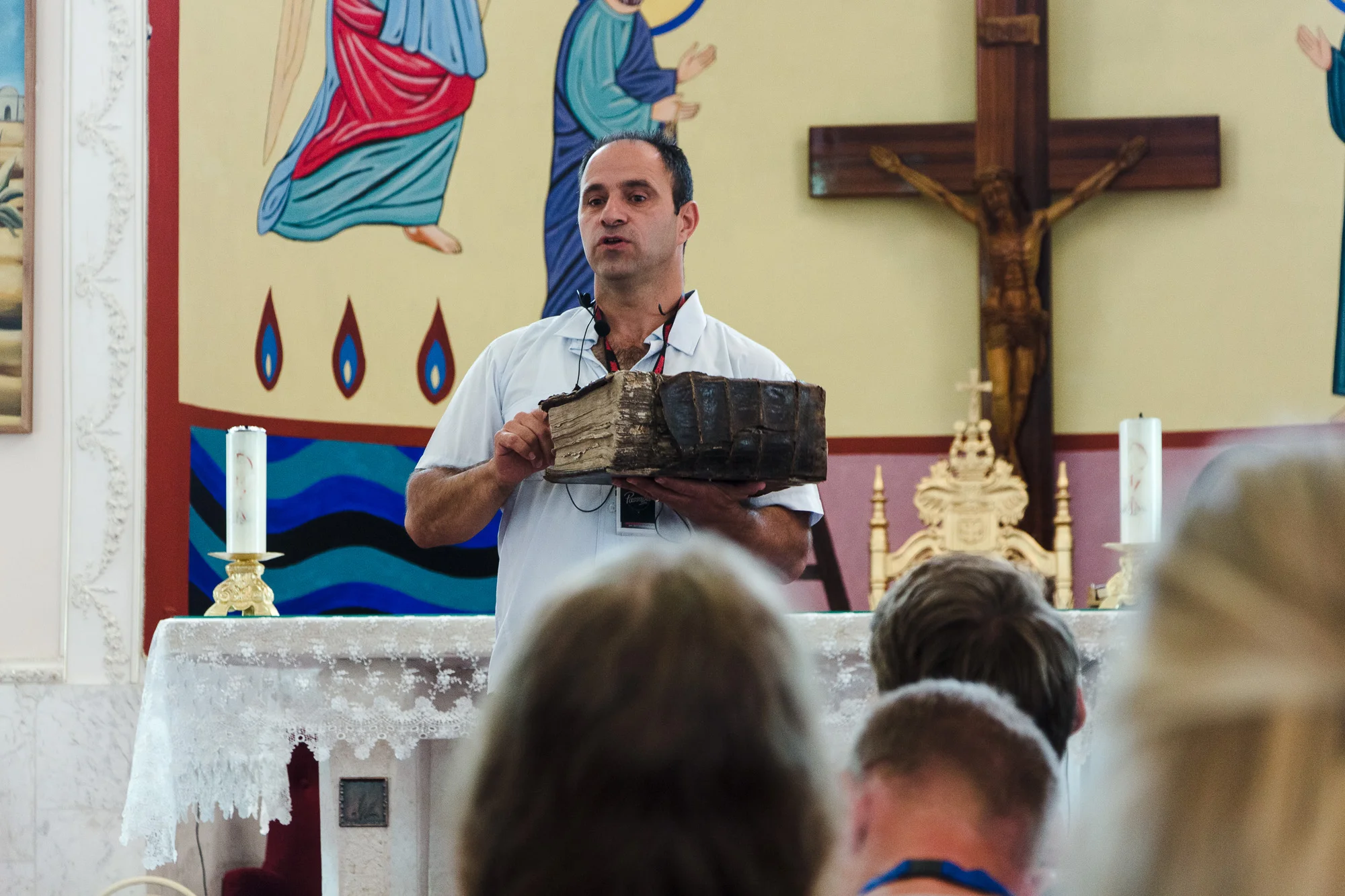 Shadi Khalloul presents an ancient Aramean Bible while speaking to a group of students at the Syriac Maronite Church of Antioch in Jish.