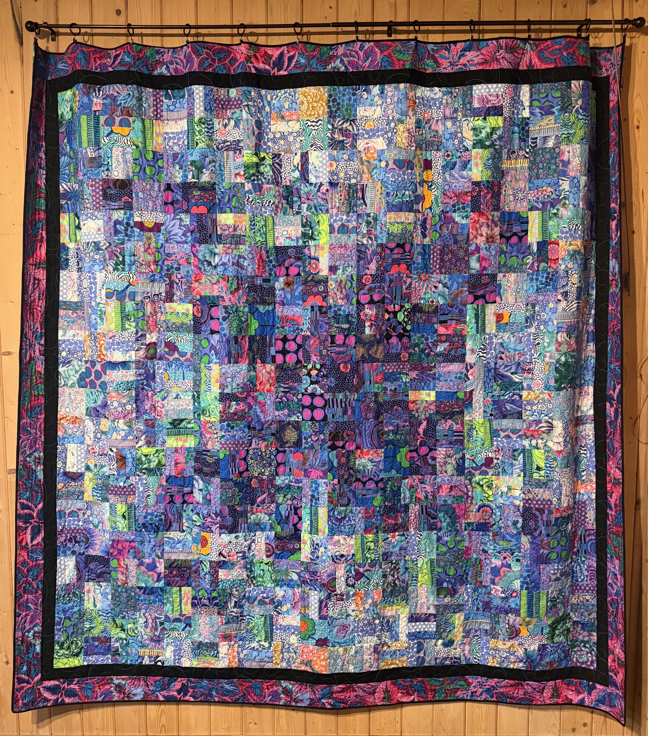 Beautiful quilt with a lively pattern of purples, blues and greens