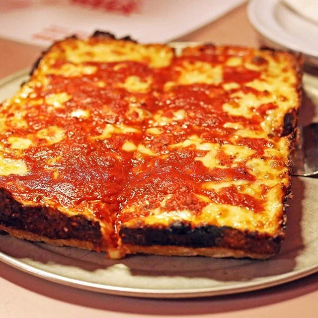 There are straw-bottomed chianti bottles everywhere inside Loui's, but even so, it kind of reminds me of a dim sum palace, or even an ancient Egyptian tomb.
🍕
Inside, it's brick. No windows. A huge rectangle of a dining room with pink Formica booths