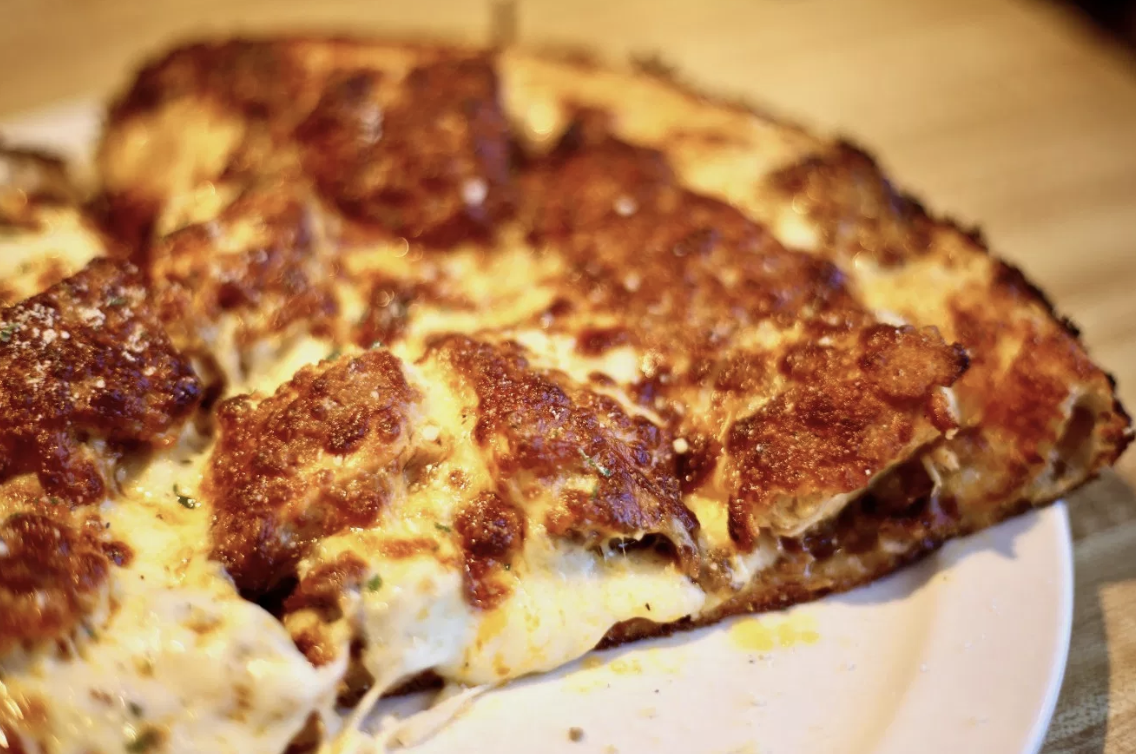 A blue cheese and wing sauce base, chicken fingers, steak, fried onions, mozzarella, and provolone.