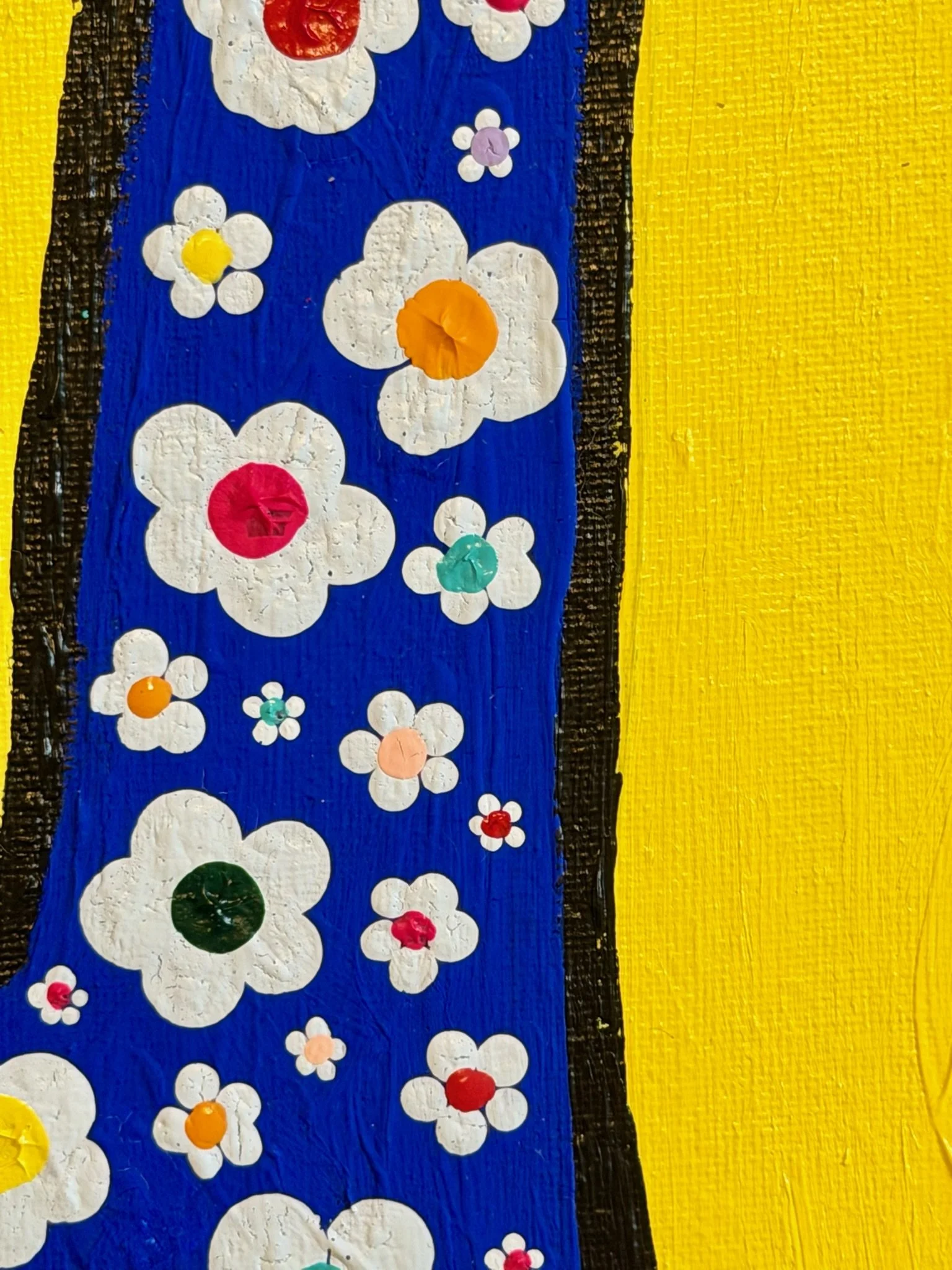 Close-up of hand-painted white flowers with colorful centers layered over the royal blue peace-sign fingers.