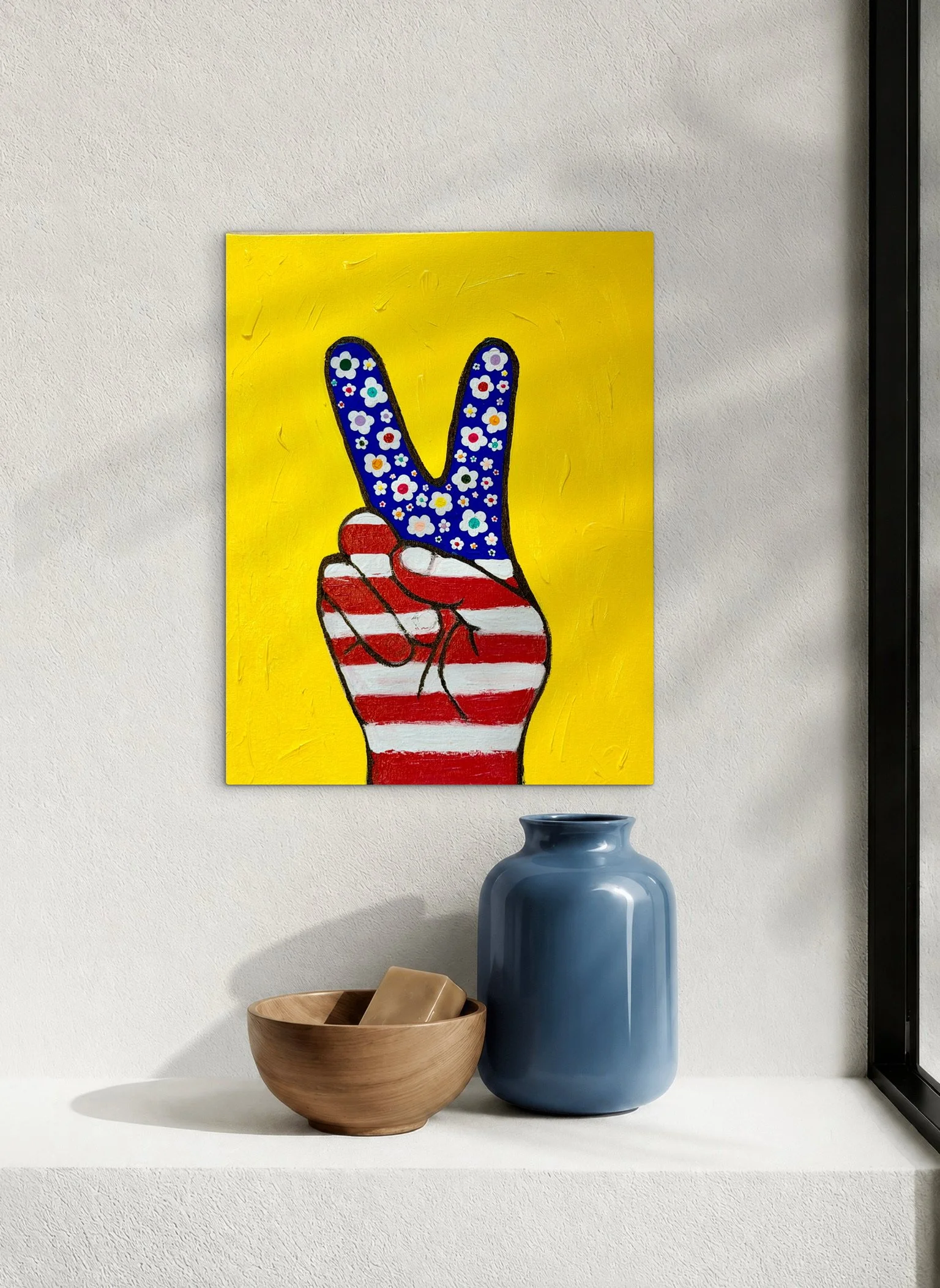 Peace by SUPERBLOOM displayed on a light wall above a shelf with a blue ceramic vase and wooden bowl.