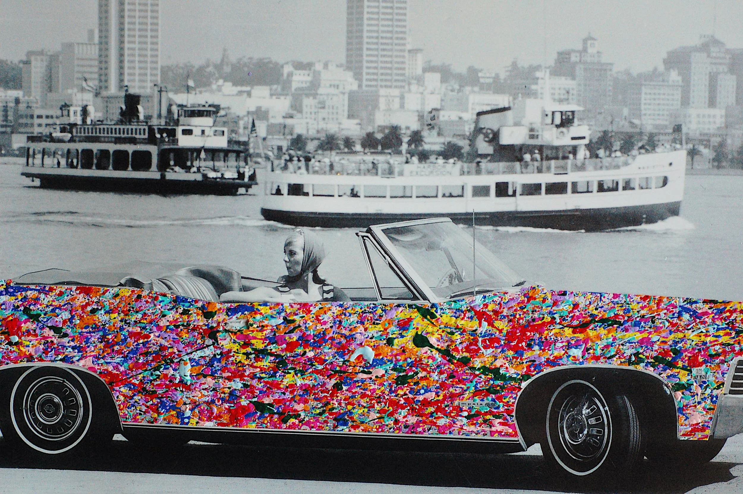 Detail of the rear side of a 1967 Chevrolet Impala convertible featuring dense, multicolored paint splatter over a monochrome photographic landscape.