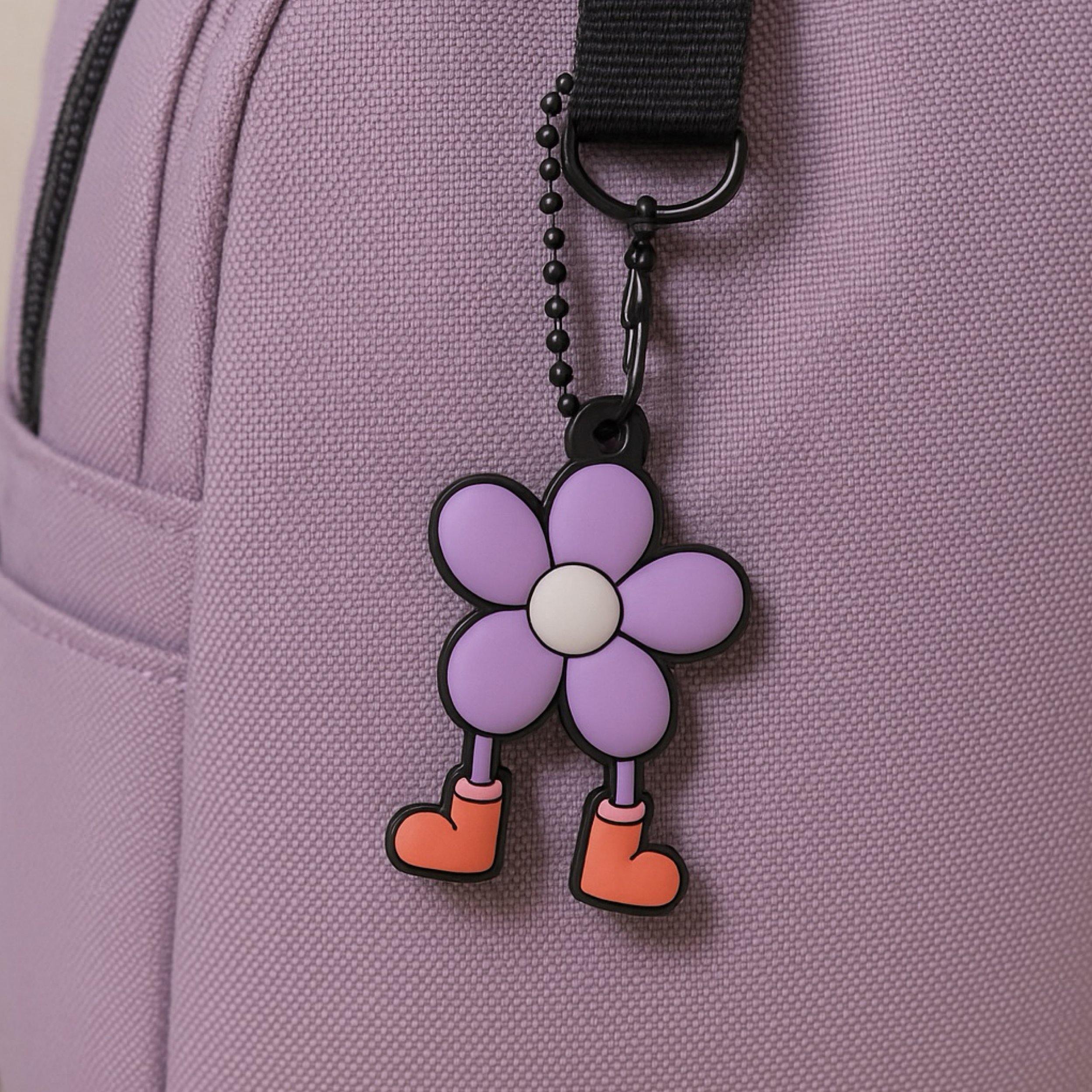Dandy Bloomer flower keychain attached to a lavender backpack strap, used as a playful bag charm and decorative accessory.