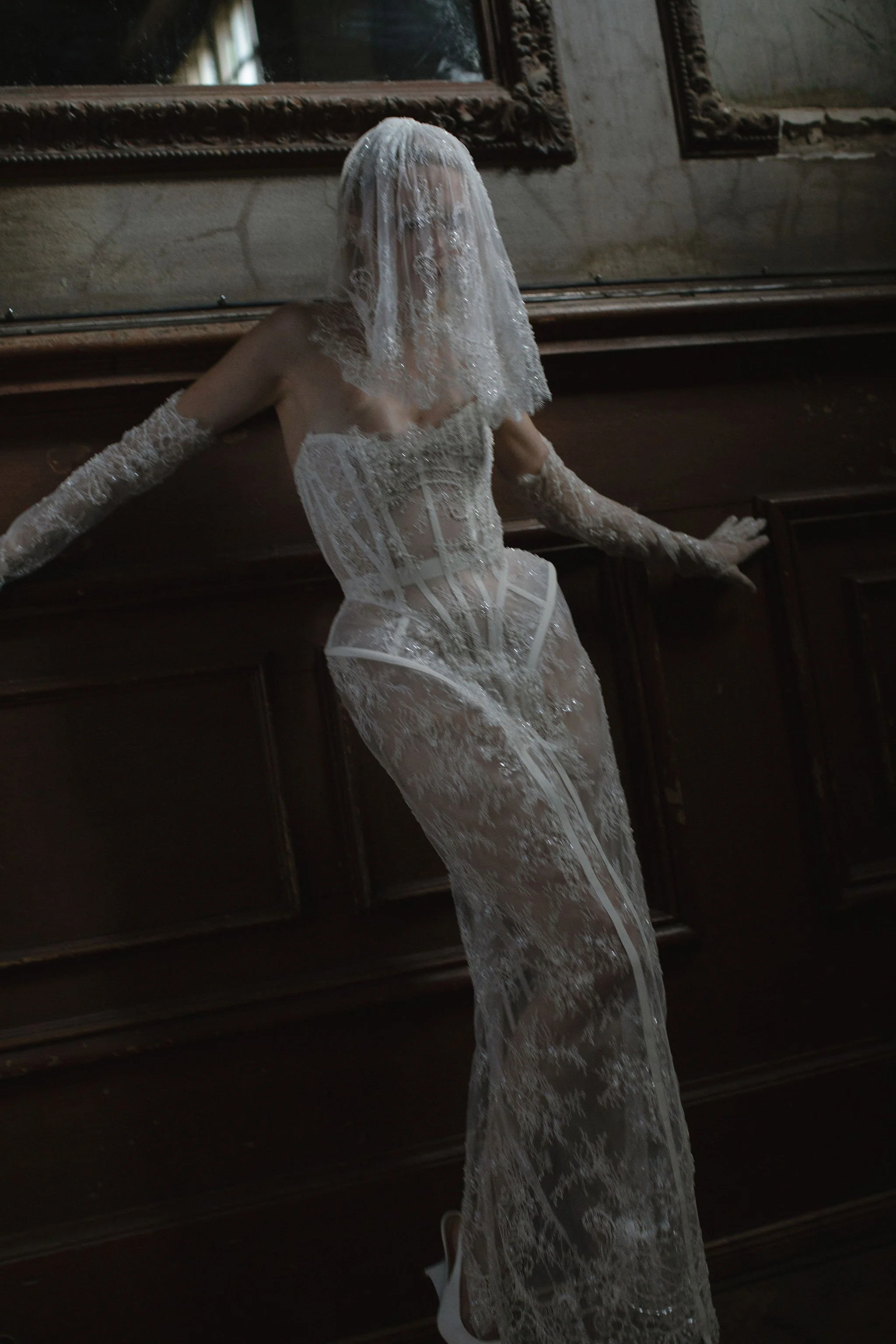 Model wearing an edgy full lace bridal couture dress with matching gloves and veil