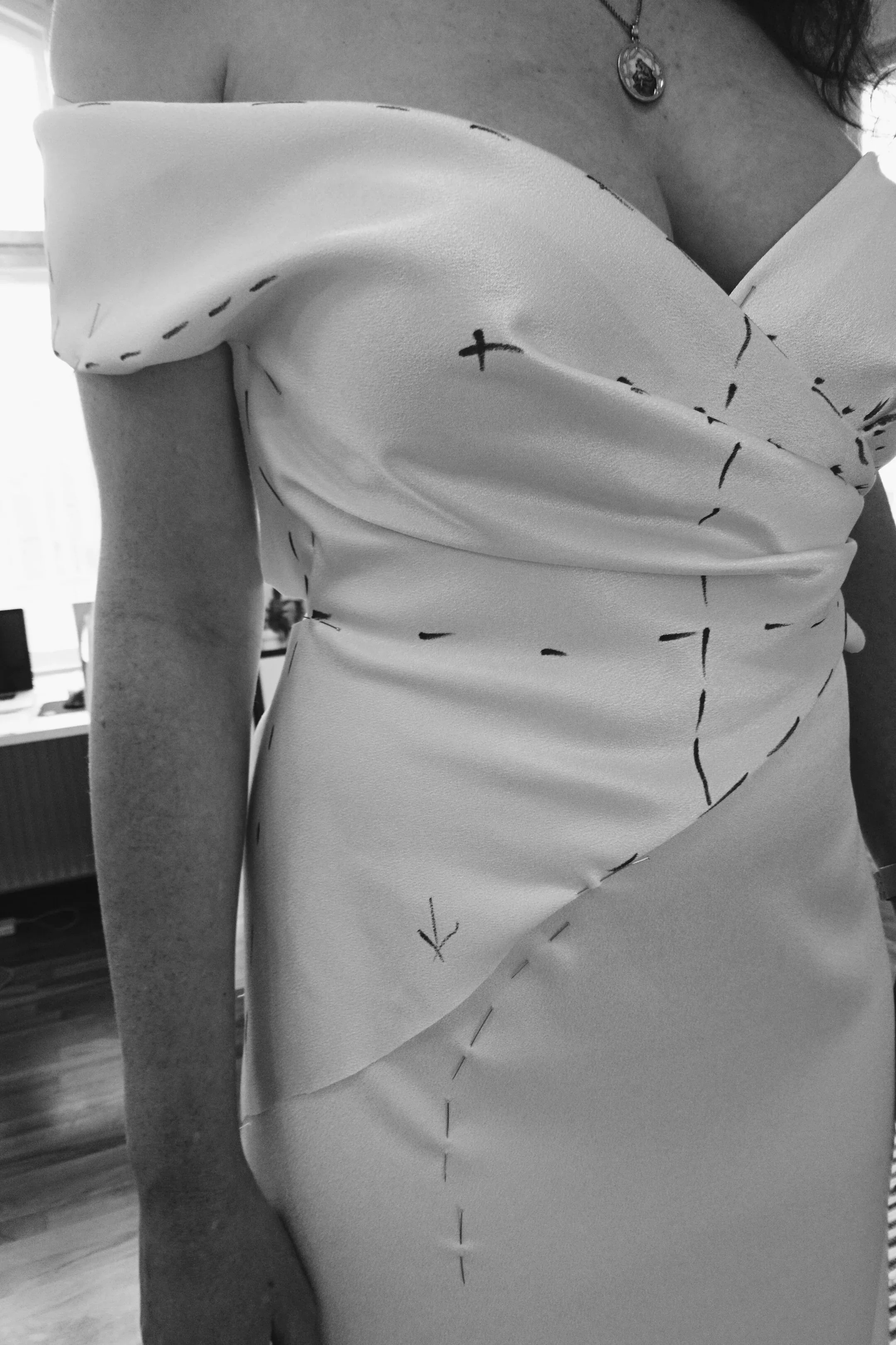 Close-up of a bride during a couture fitting with visible draping and construction marks
