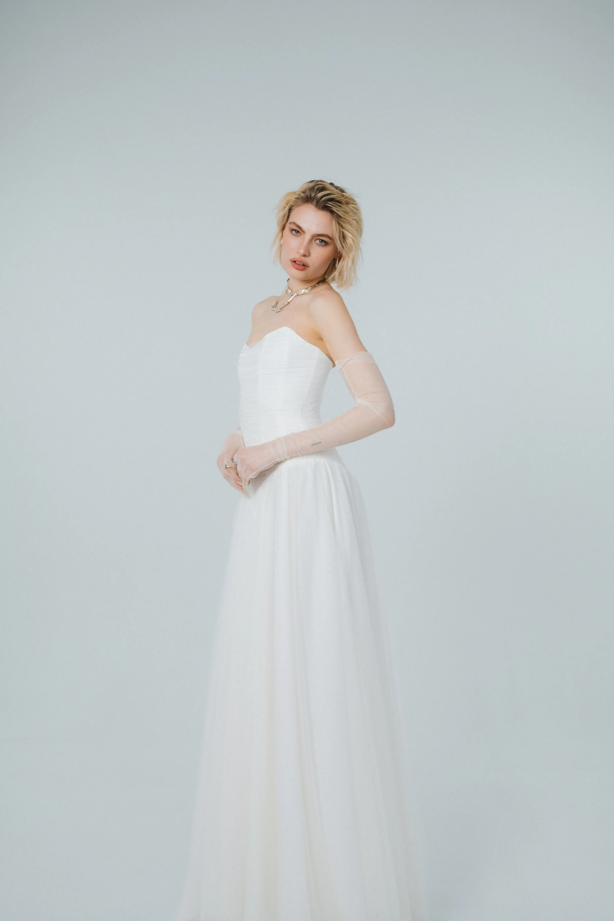 Side view of ethereal soft tulle wedding dress with dropped waist and layered flowing skirt