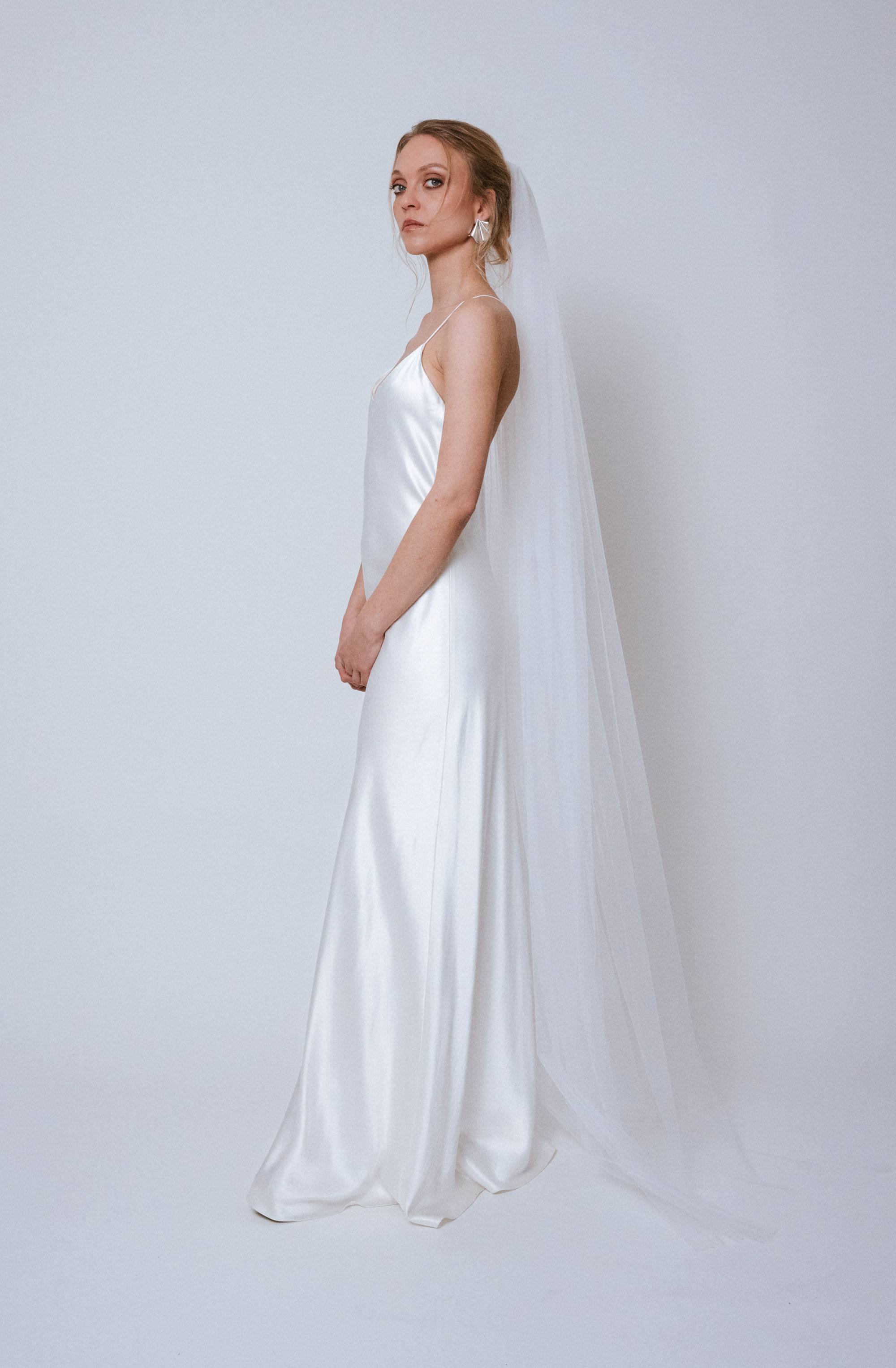 Side view of the chapel-length Purity Veil flowing softly behind the model